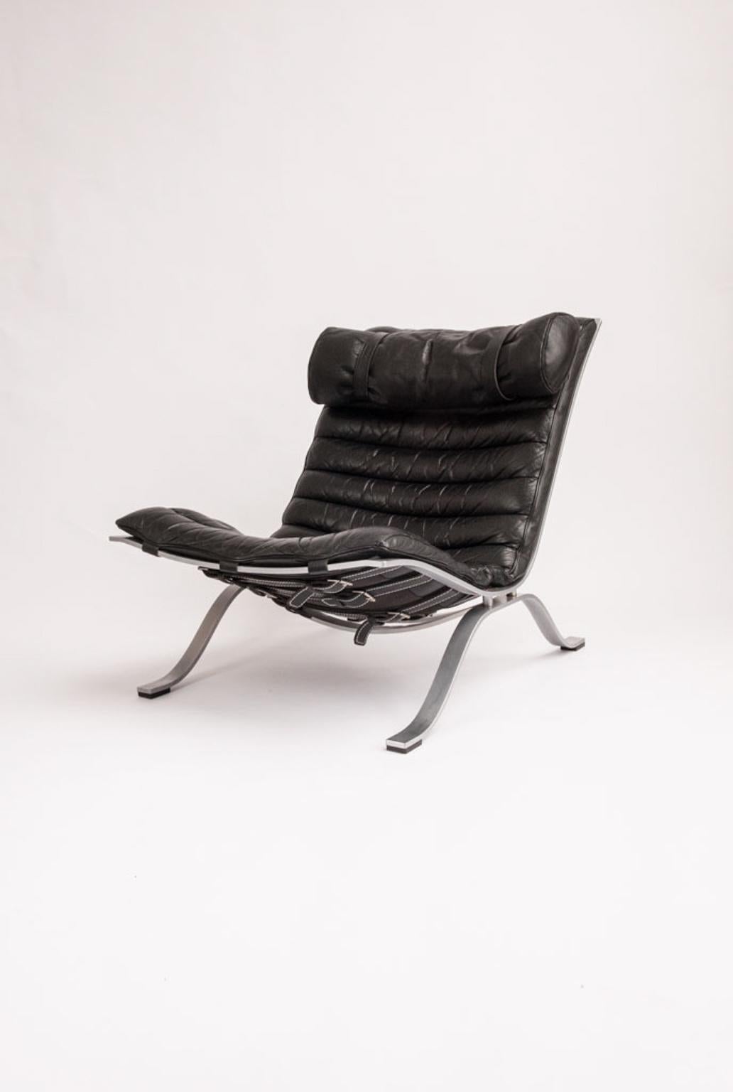 The easy chair Ari is Norells most well-known and appreciated piece, designed in 1966. Loose cushions upholstered in black patinated buffalo leather. Satin chromed flat steel base. Produced by Norell Møbel AB.