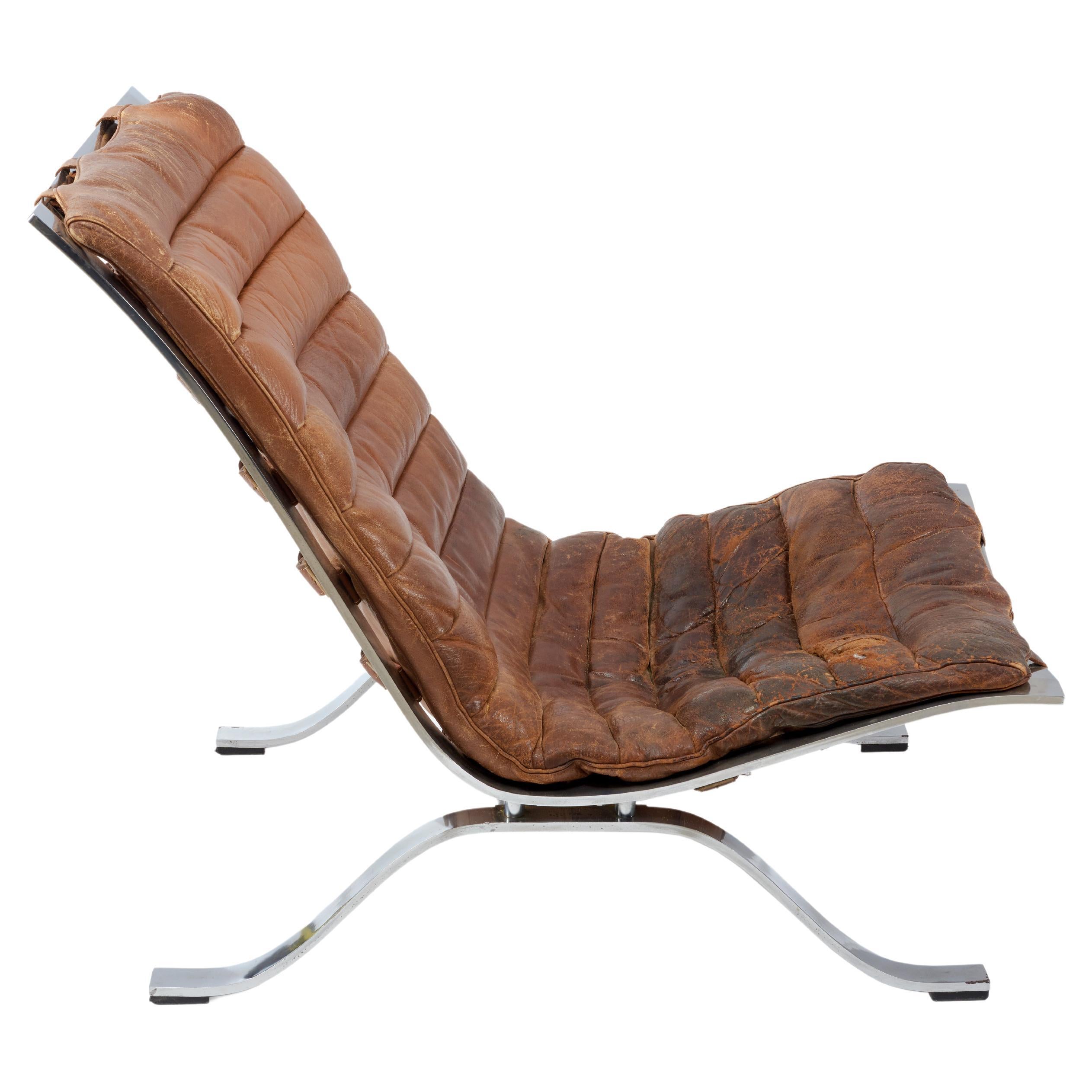 The famous Steel framed leather 'Ari' Lounge chair by Legendary Swedish designer Arne Norell from 1966.
This vintage rugged and beautifully aged chair comes with it's original leather cushion, straps  and chrome frame. There is  patina to the