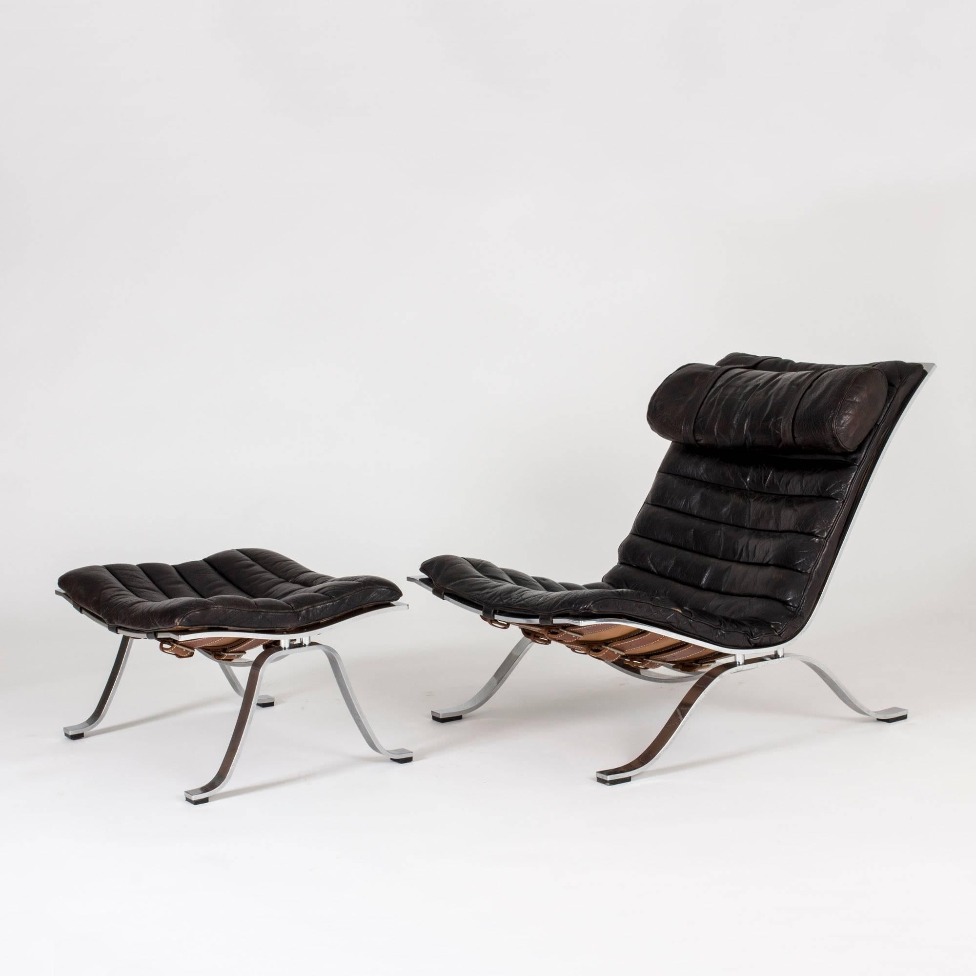 Incredibly cool and oh so comfortable “Ari” lounge chair with stool by Arne Norell, made from steel and leather. Beautiful black leather with nice patina.

Dimensions of the stool: H 34, W 65, D 50 cm.