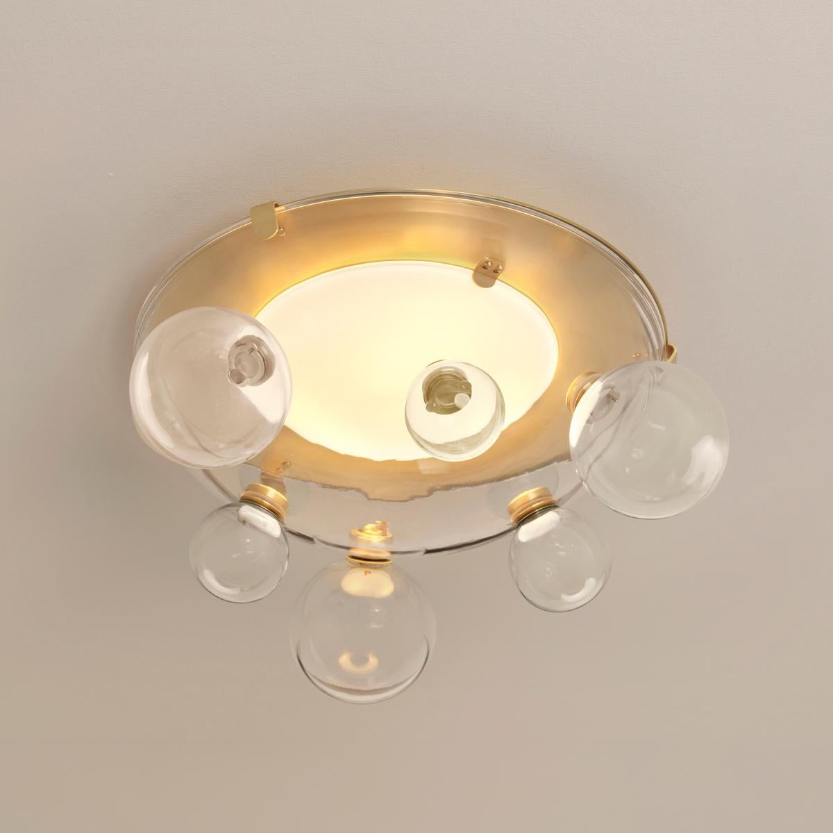 Airiness and playfulness intertwine in the Aria collection. Composed of a thick glass handblown semi-sphere, this unique piece allows for a wide variety of configurations via its smaller accent globes which can freely and easily be attached at up to