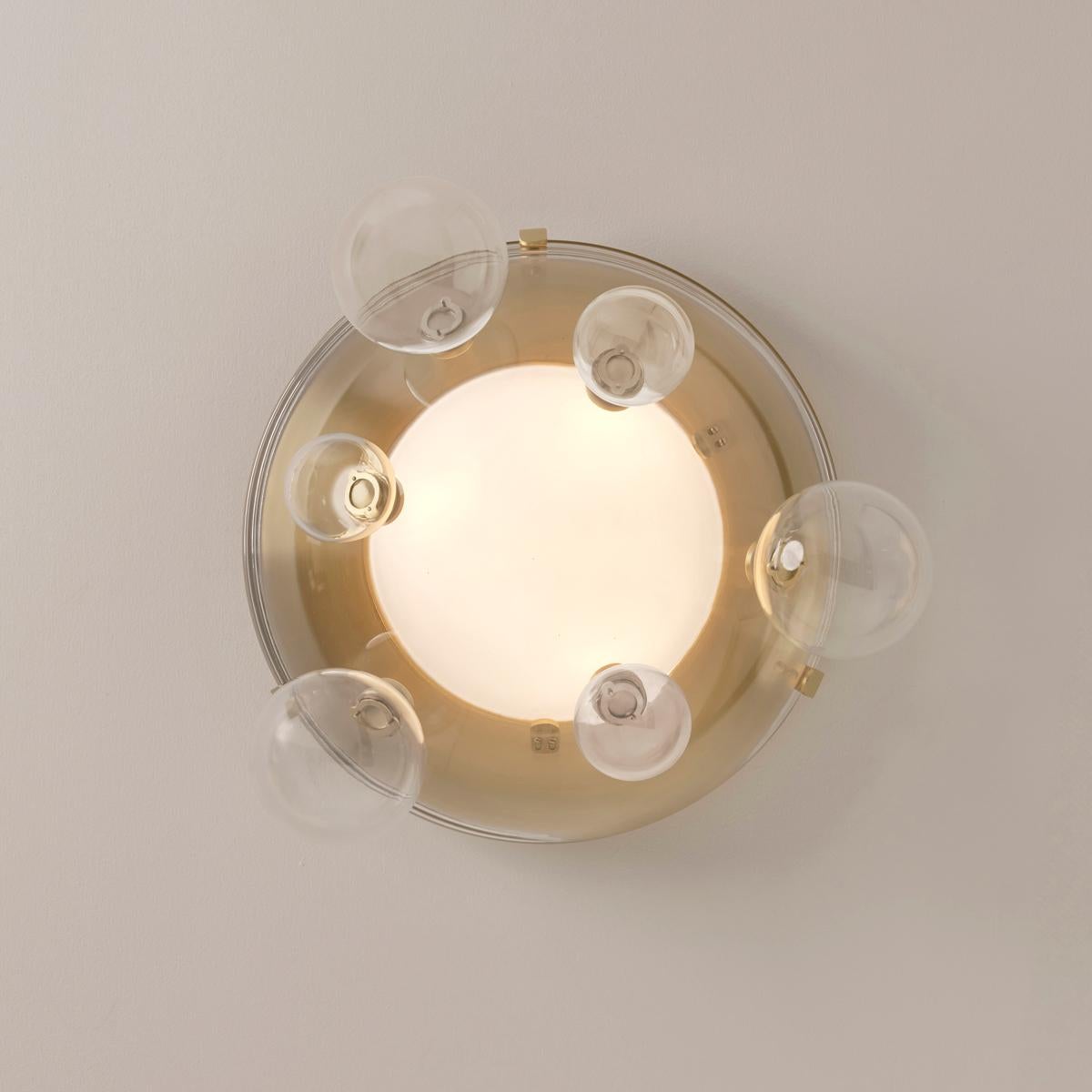 Airiness and playfulness intertwine in the Aria collection. Composed of a thick glass handblown semi-sphere, this unique piece allows for a wide variety of configurations via its smaller accent globes which can freely and easily be attached at up to