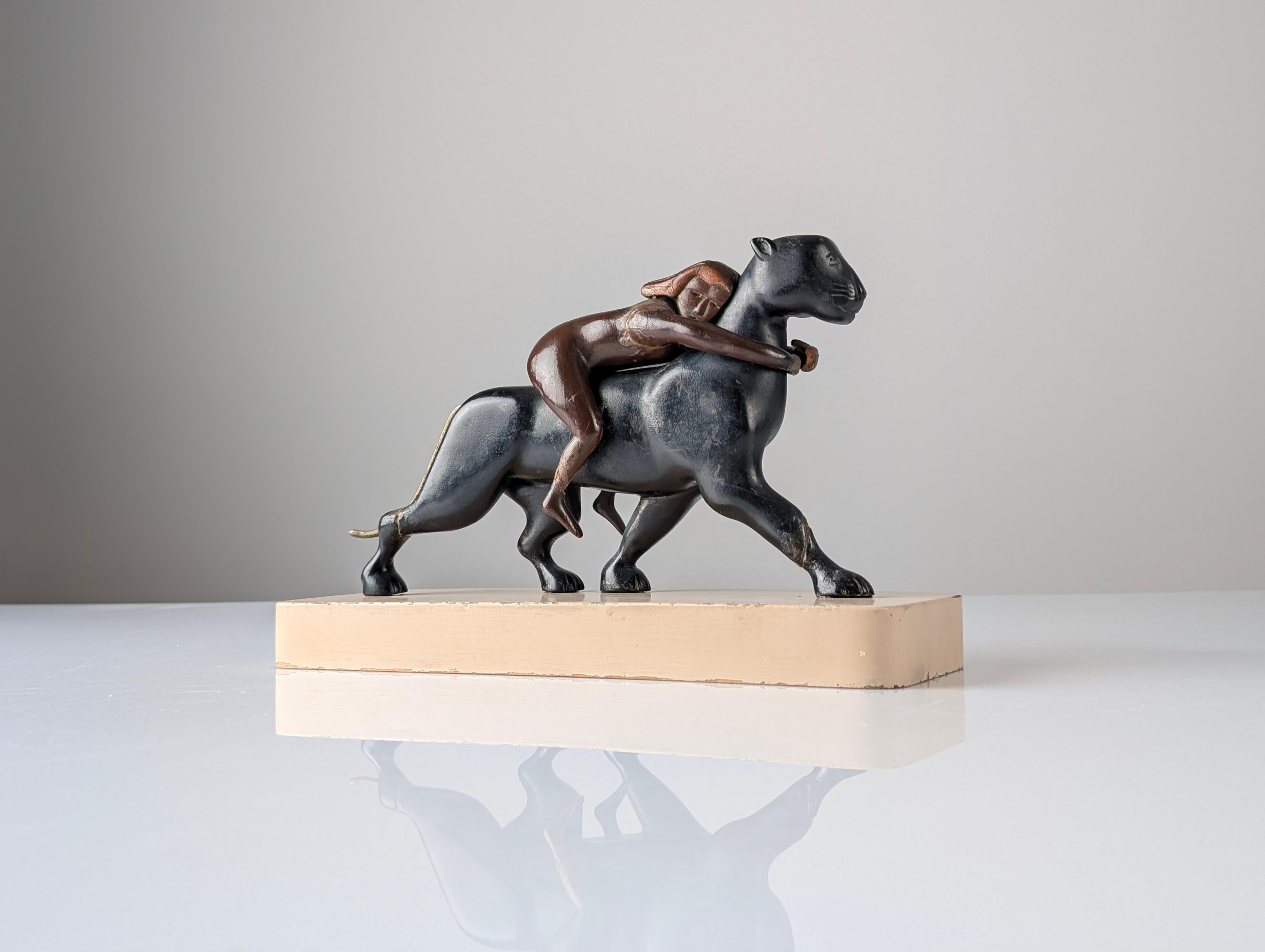 This captivating Art Deco sculpture, created around 1920, is inspired by the depiction of Ariadne, the heroine of Greek mythology, atop a majestic panther in motion. Crafted from carved wood, with the panther's tail made of brass, the piece embodies