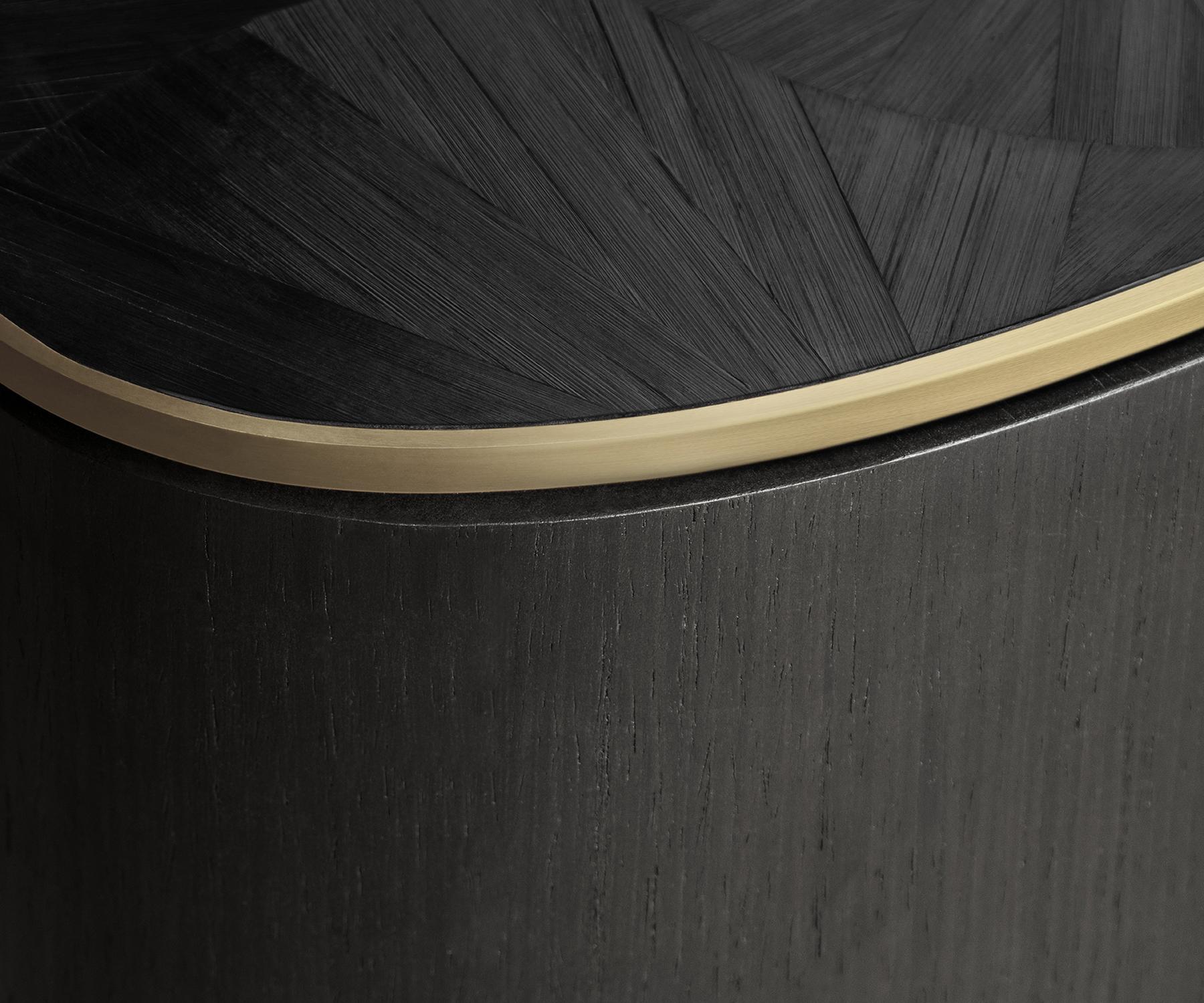 The Arain centre table is impeccably crafted in veneer with dramatic visual impact.

Its top features charcoal straw marquetry along with a brushed brass trim circling both the top and bottom edges, framing the composition.

The Arain centre table