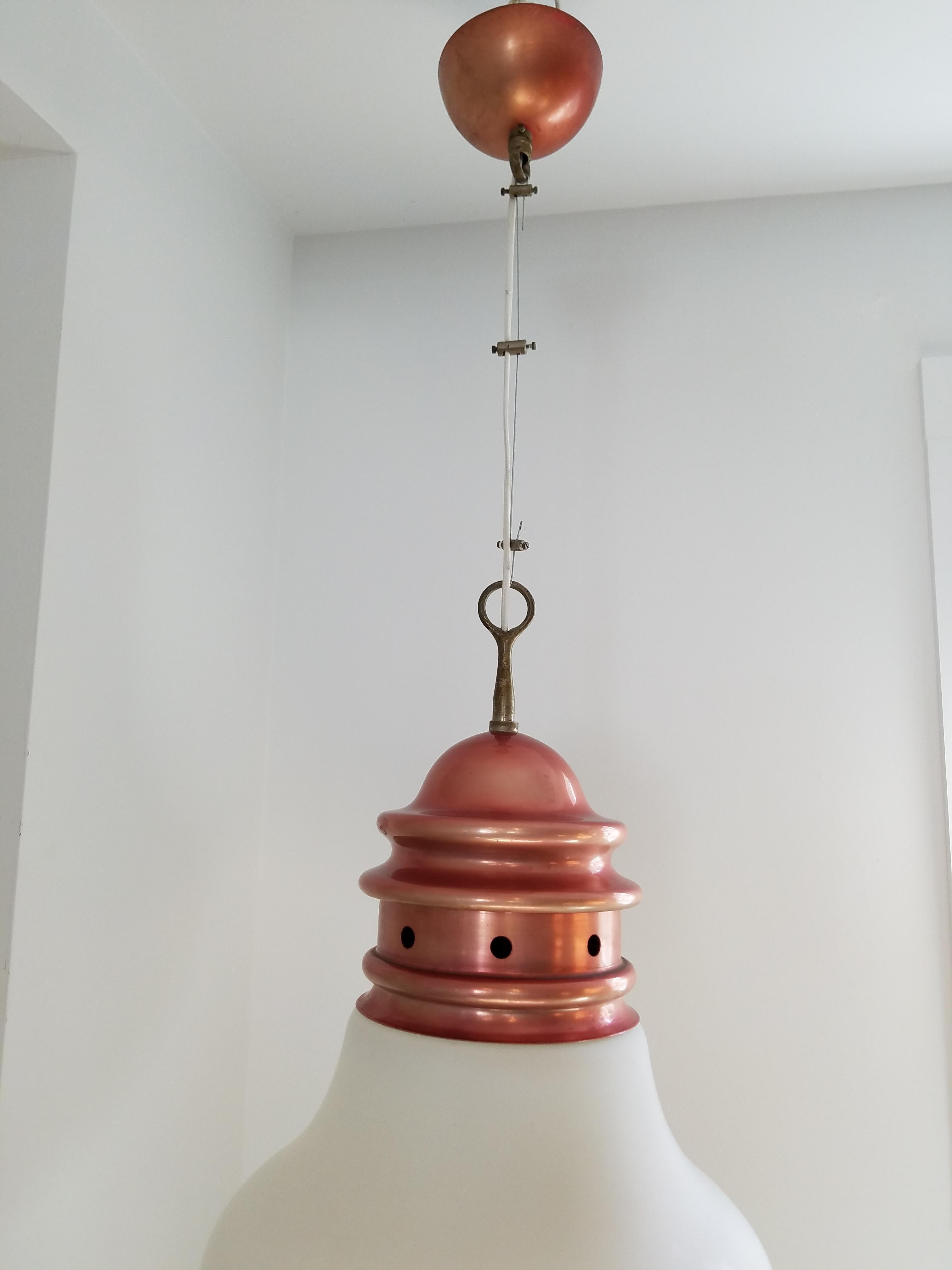Conçue par Piero Brombin pour Artemide, cette lampe suspendue est une suspension en fil de fer dans l'esprit du mouvement OpArt du milieu des années 1960. Fabriqué en cuivre avec un abat-jour en verre opalin dans la forme classique d'une ampoule