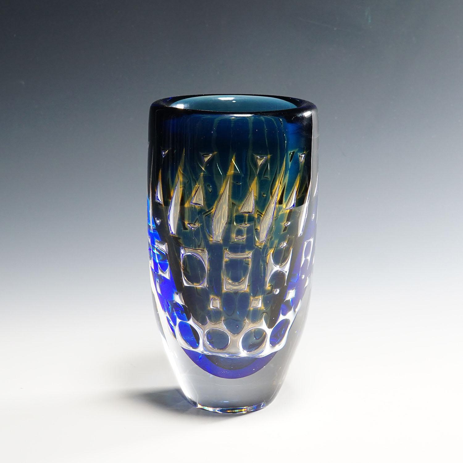 Ariel Vase by Ingeborg Lundin for Orrefors, Sweden.

A heavy vase of the Orrefors Ariel series designed by Ingeborg Lundin, Sweden ca. 1950s. Colorless glass with a blue overlay, cooled, sandblasted with a geometrical pattern, re-heated and cased