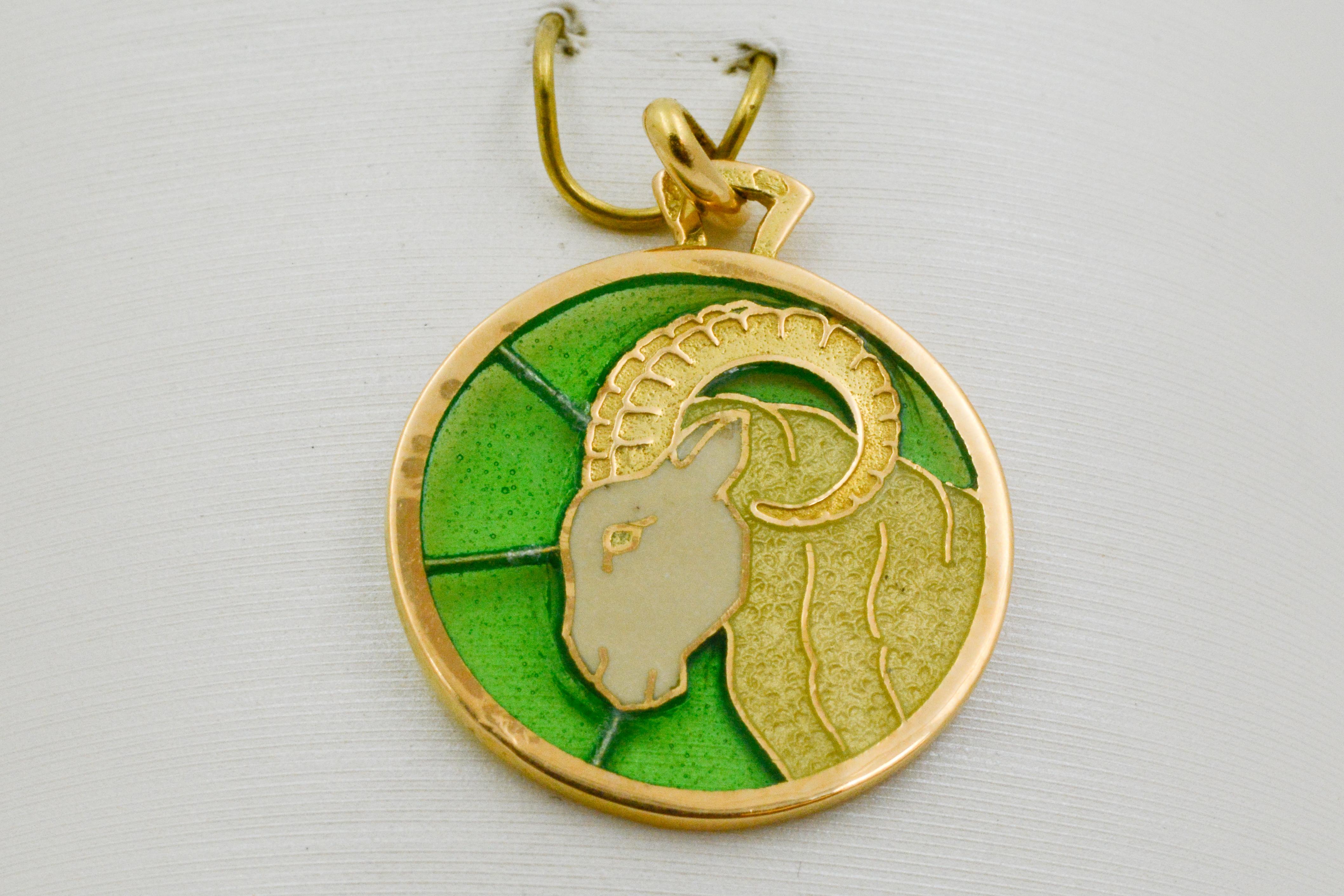 Plique a jour hand enameled glass Aries pendant. Light as a feather with intricate detailing in 18 karat yellow gold and handmade enameled glass showcasing a magnificent ram on a brilliant green background.