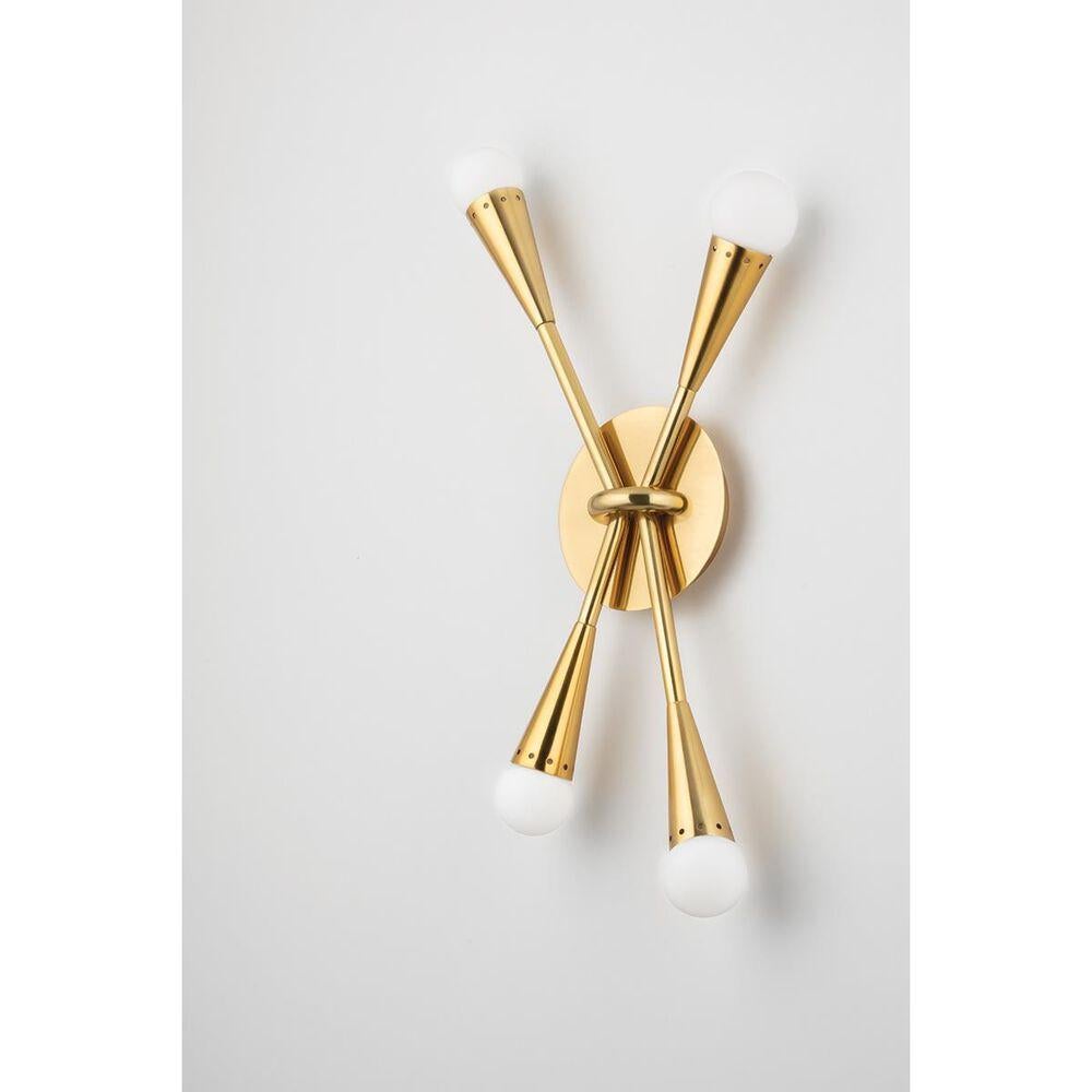 Martyn Lawrence Bullard for Corbett Lighting
The Aries Wall Sconce features tapered conical arms in vintage polished brass bursting from a metal ring of black brass. 
A soft glow pours from the opal glass globes in every direction. 
The brass is