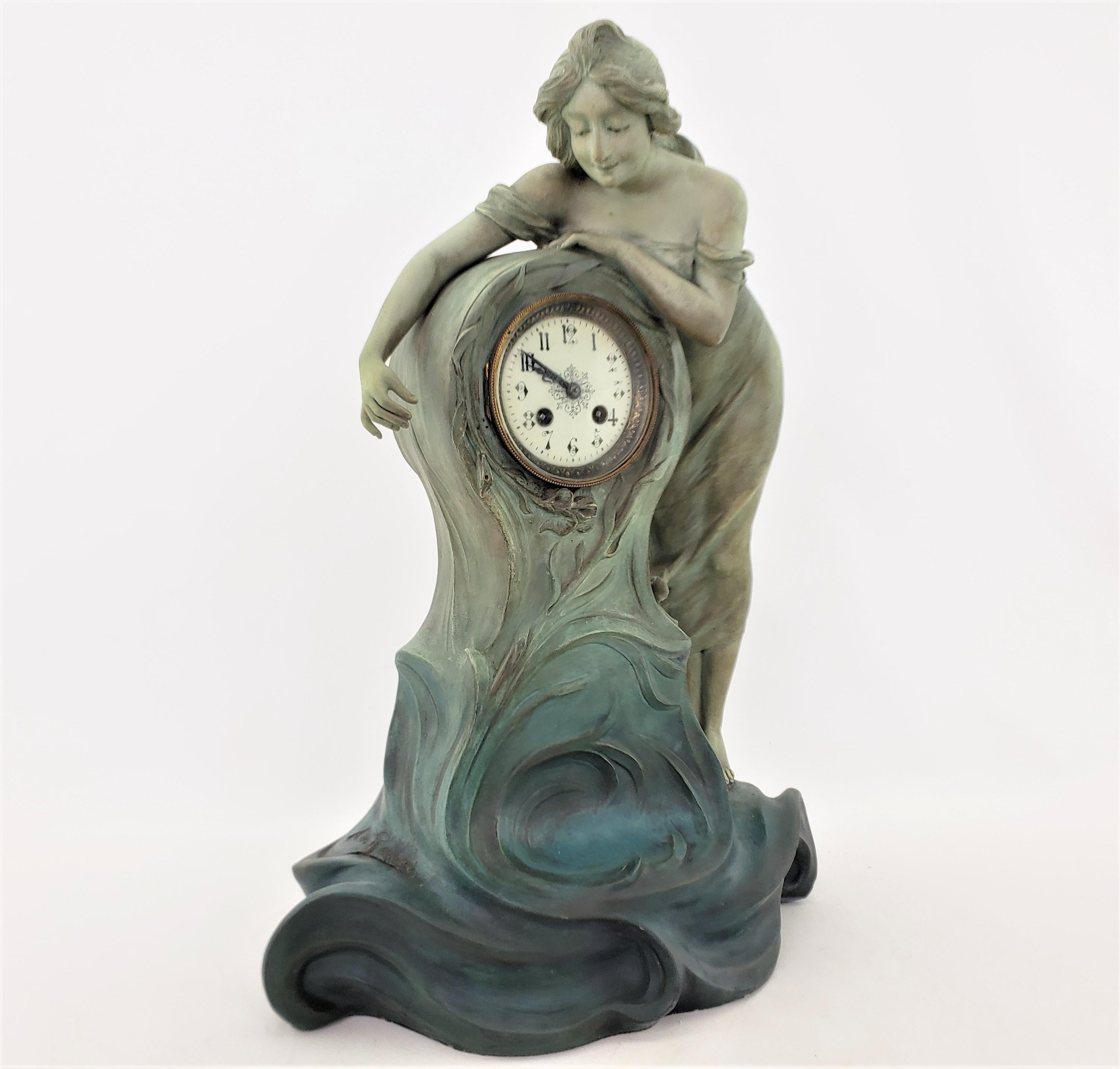 Thia antique mantel or table clock was made by the well known Italian born sculptor Archimede de Ranieri, who did much of his work in France and made this in approximately 1900 in the period Art Nouveau style. The sculptural clock case is composed
