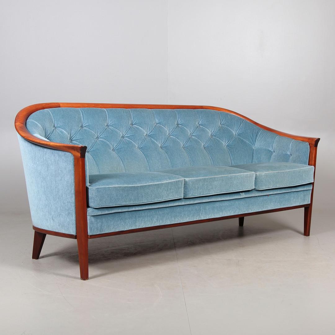 Le canapé en bois de teck avec revêtement d'origine en parfait état, appartenant au modèle Aristokrat conçu par Bertil Fridhagen en 1960, est une pièce exceptionnelle qui fusionne l'élégance du design scandinave avec la durabilité et la beauté