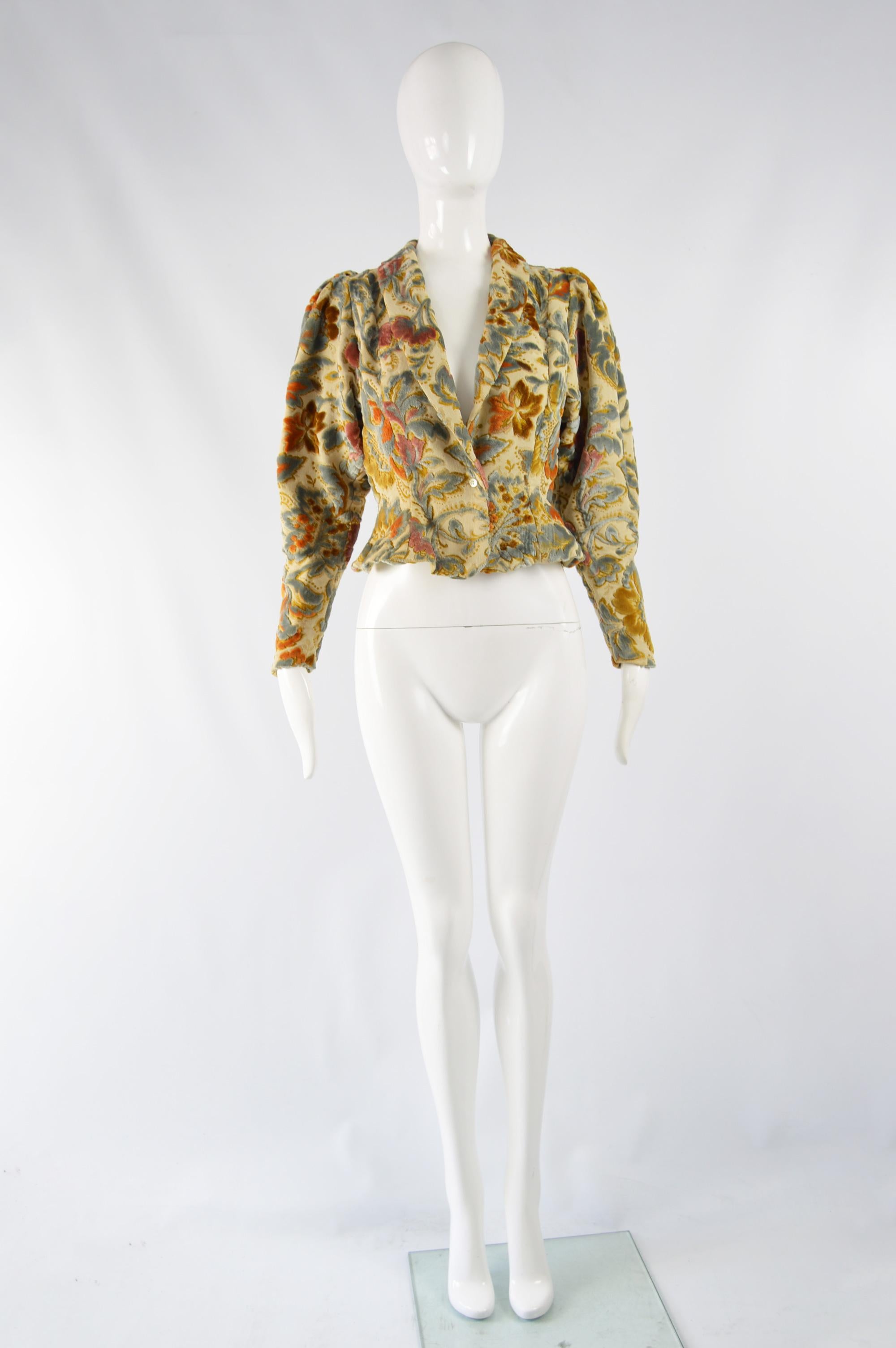 A fabulous vintage women's peplum jacket from the 70s by legendary British fashion label and Carnaby Street boutique, Aristos. In a beige fabric with chenille / velvet flocking throughout giving a floral tapestry effect. The huge puff sleeves give a