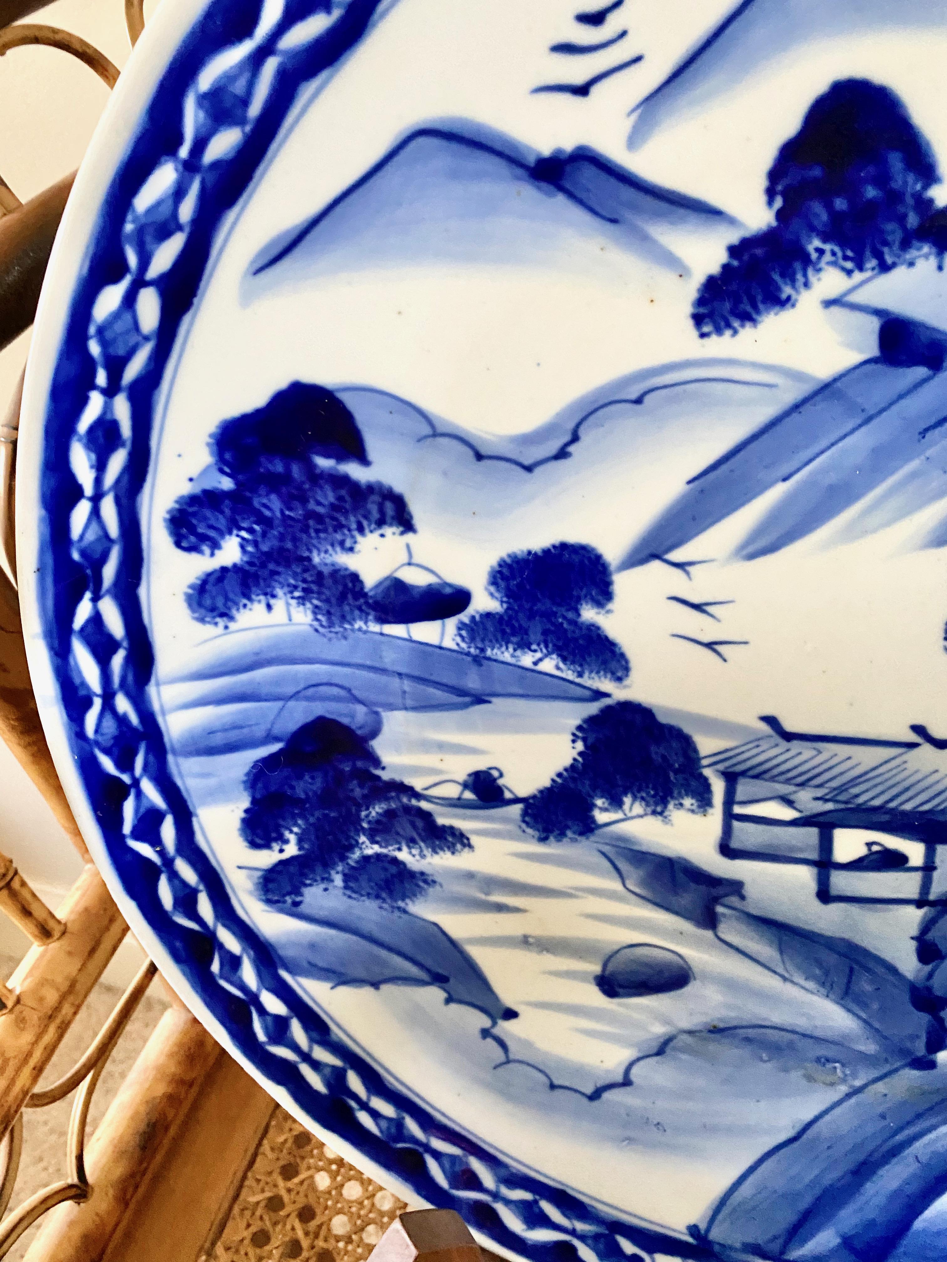 This is charming large mid-20th century Japanese Arita blue & white charger that depicts a country mountain scene. The charger would make a great addition to a country kitchen or breakfast room. The charger is in overall very good to excellent