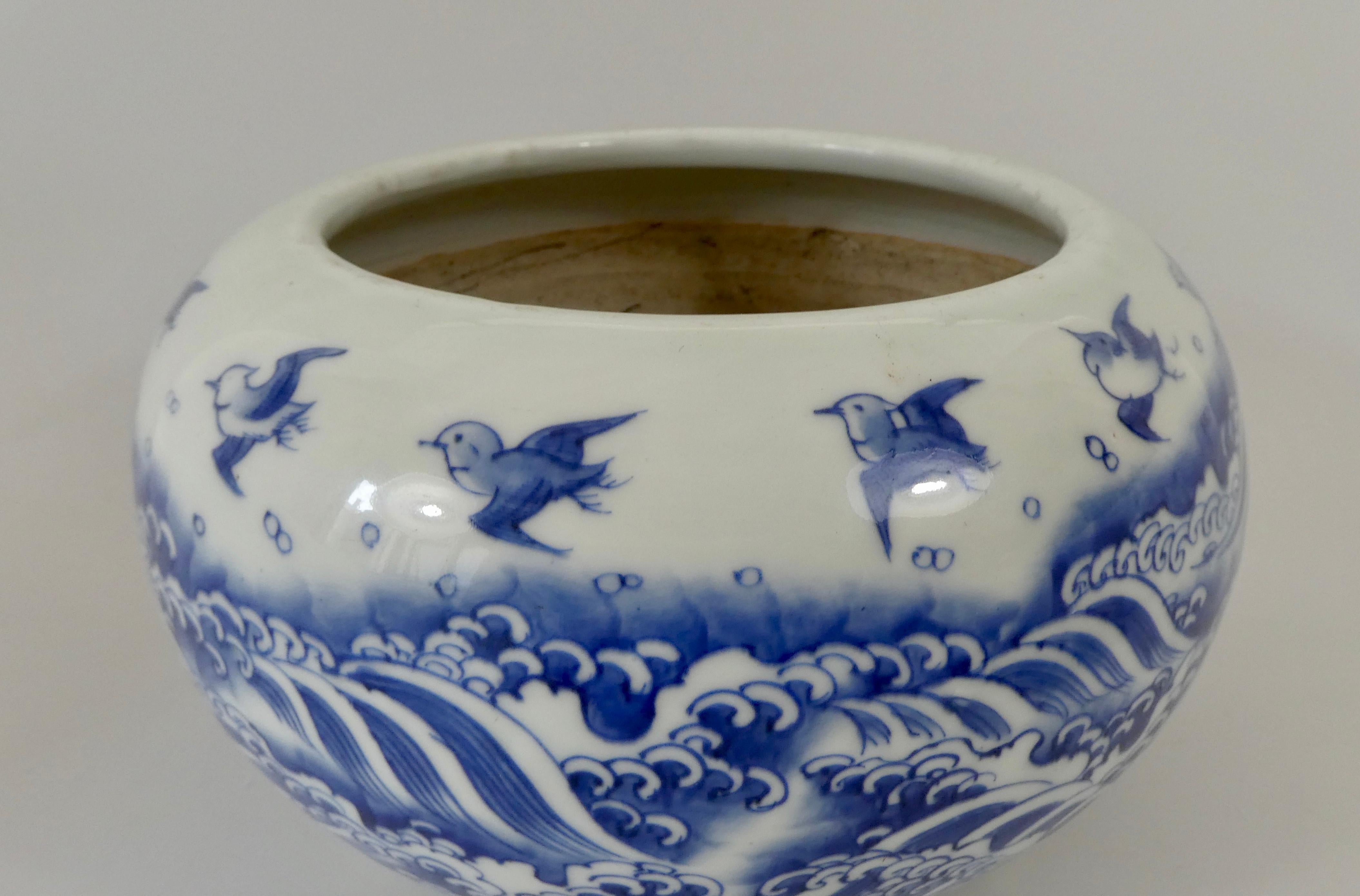 A Japanese porcelain censer, Arita, circa 1890, Meiji Period. The globular body painted in underglaze blue, with a continuous scent of birds, flying above crashing waves. Set upon three stub feet.
Measures: Diameter - 25 cm, 9 7/8”.
Height - 16