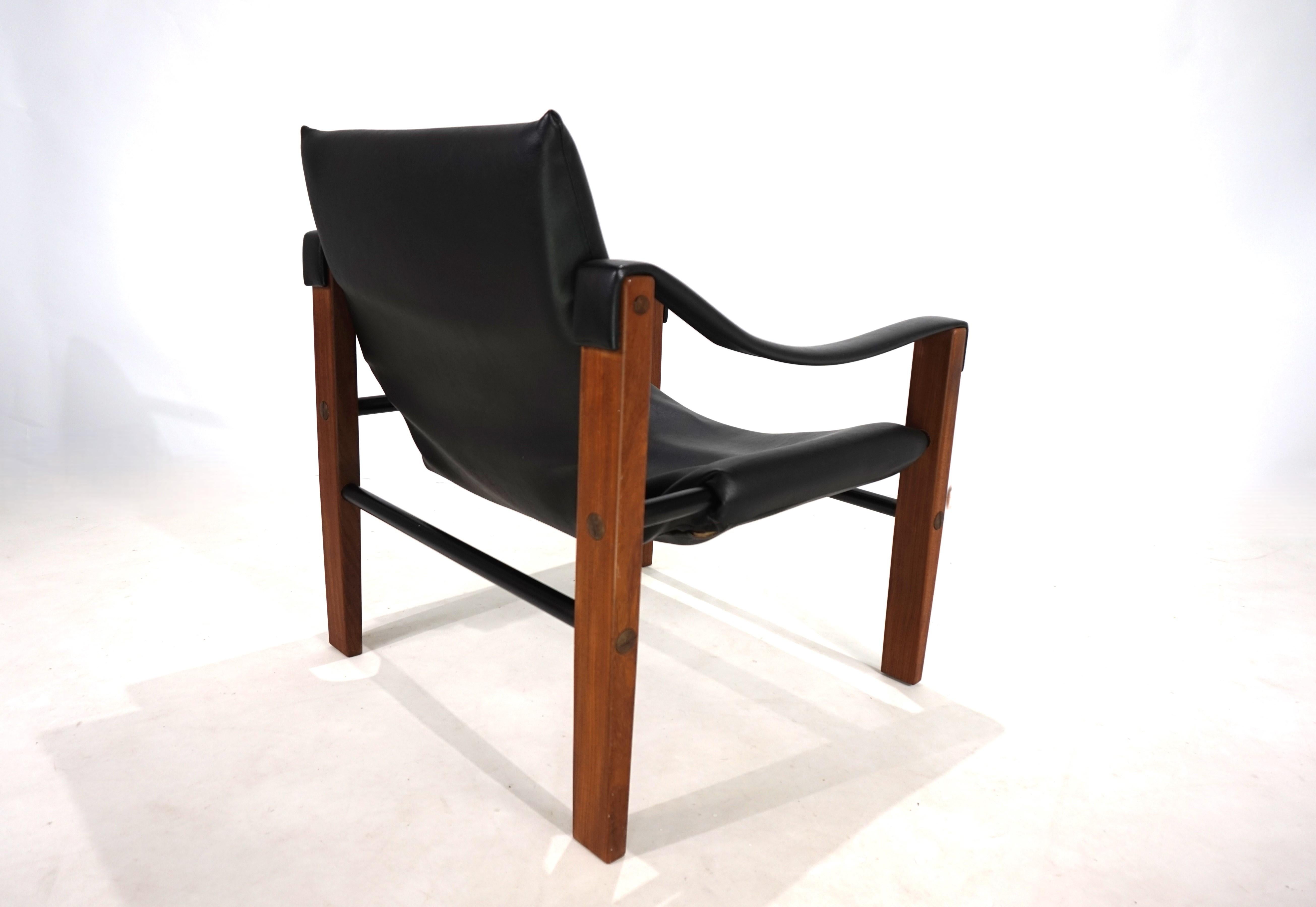 Sillón Safari de Maurice Burke en excelente estado. La piel sintética negra está suspendida de varillas metálicas lacadas en negro, prácticamente no muestra signos de desgaste y ofrece una comodidad de asiento excelente. El armazón de teca, con su