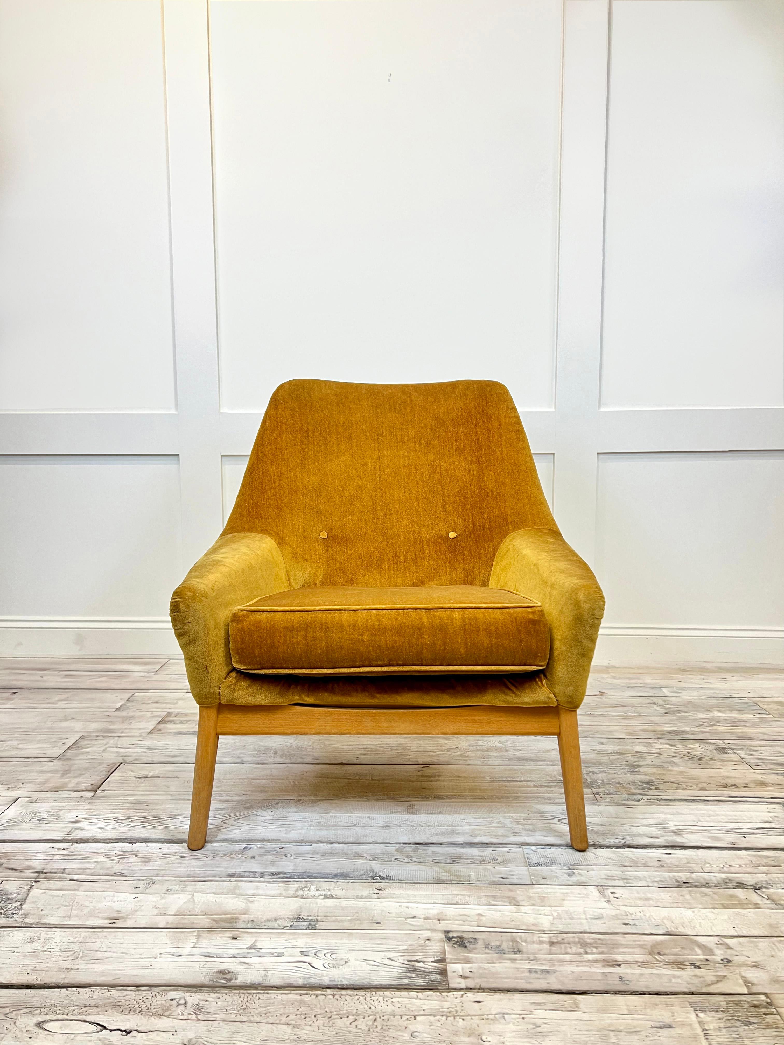 This British design iconic lounge chair has a pleasant sculpted silhouette with the innovative use of moulded plastic for it's shell base covered with a beautiful Honey Mustard Velour upholstery. It draws inspiration from the futuristic mood of