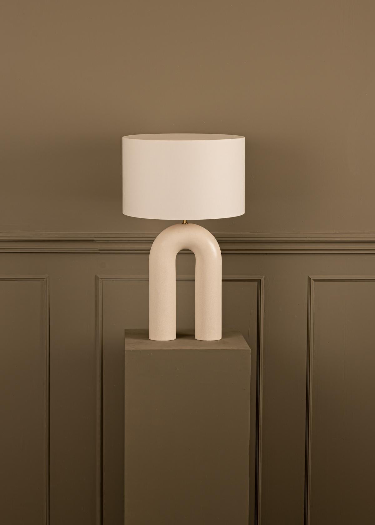 Our iconic design and its unique arch shape, inspired by the Nine Archs Bridge in Sri Lanka, making it a striking decorative piece. An unique cotton lampshade difusing a soft and harmonious light and a wide selection of colours.