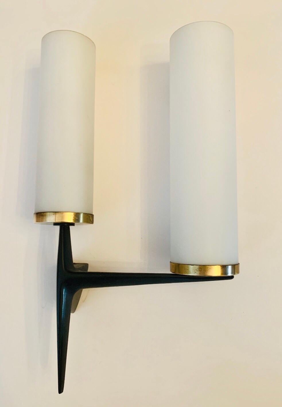 A wonderful French 1950s black matte enamel iron wall lights with white matte glass cylinder shades by Arlus. Newly rewired
