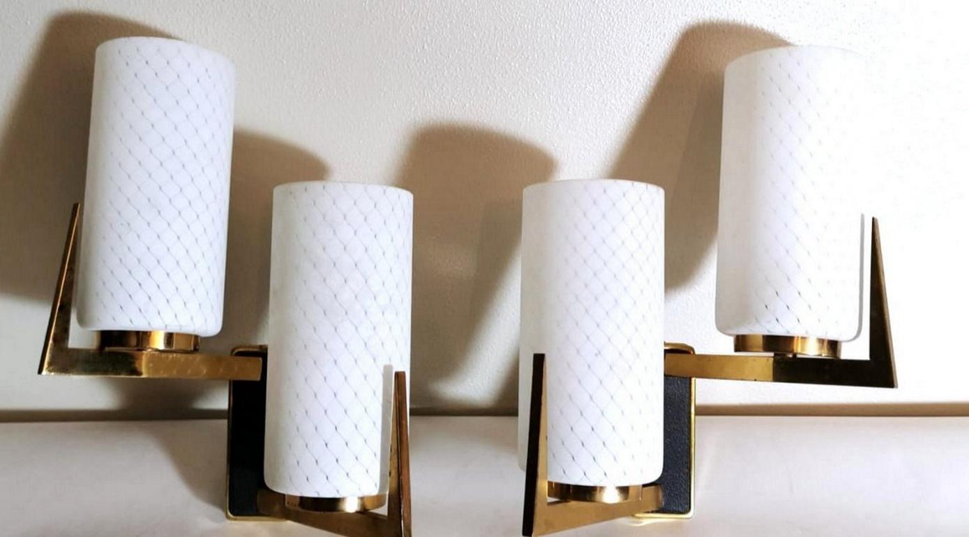 Elegant and linear pair of wall sconces; the original and solid structure is made of brushed and polished brass; the design is compact and functional; the eccentric and innovative arrangement allows an excellent and uniform illumination of the