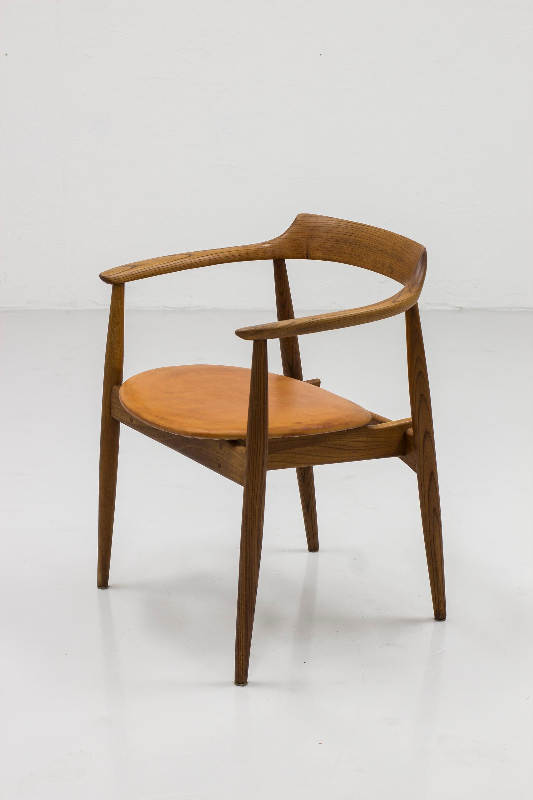 Arm chair model St-750 designed by Arne Wahl Iversen. Produced in Denmark by Danish cabinetmaker during the 1960s. Made from solid elm wood with oil finish. Seat with patinated leather in a cognac color. Very good vintage condition with minor signs