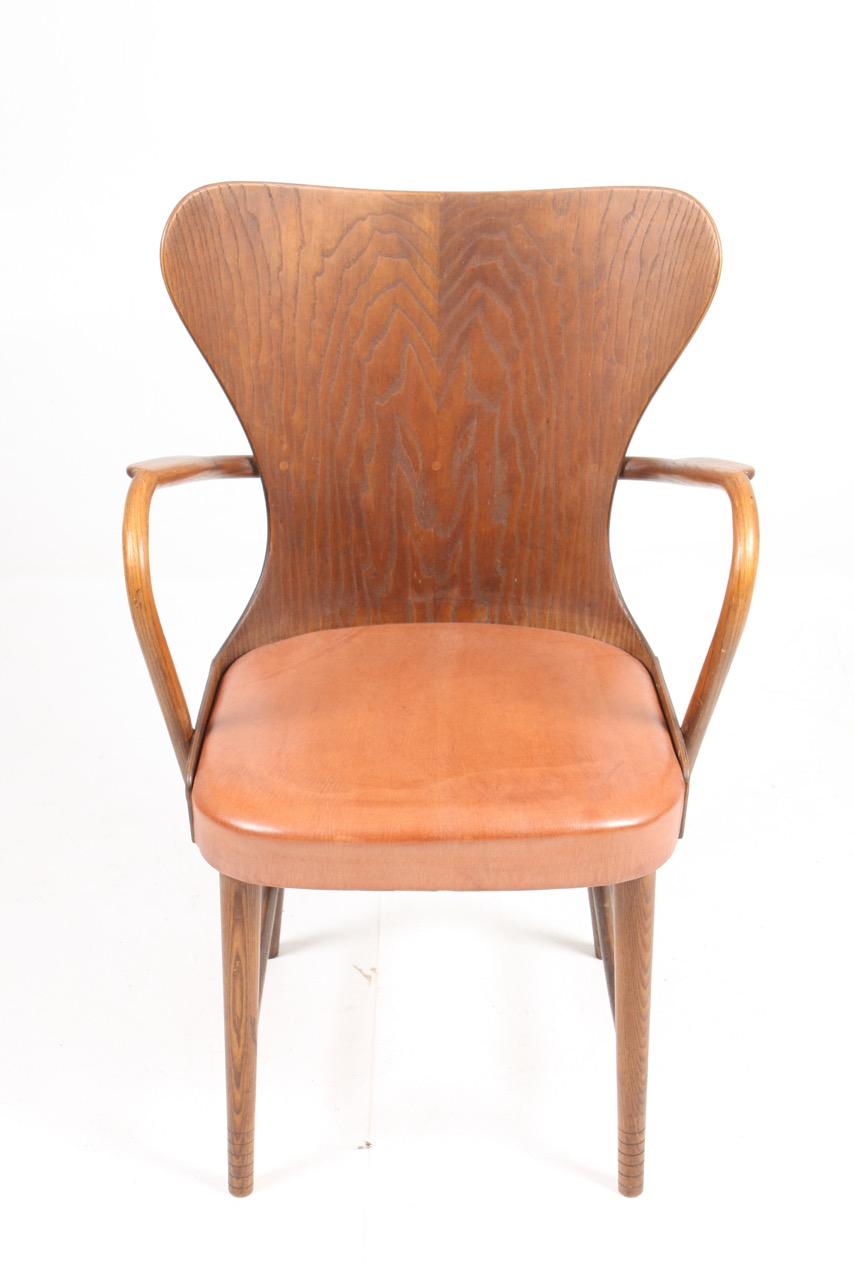 Armchair in oak and patinated leather designed and made by Fritz Hansen cabinetmakers in 1940s. Made in Denmark. Great condition.