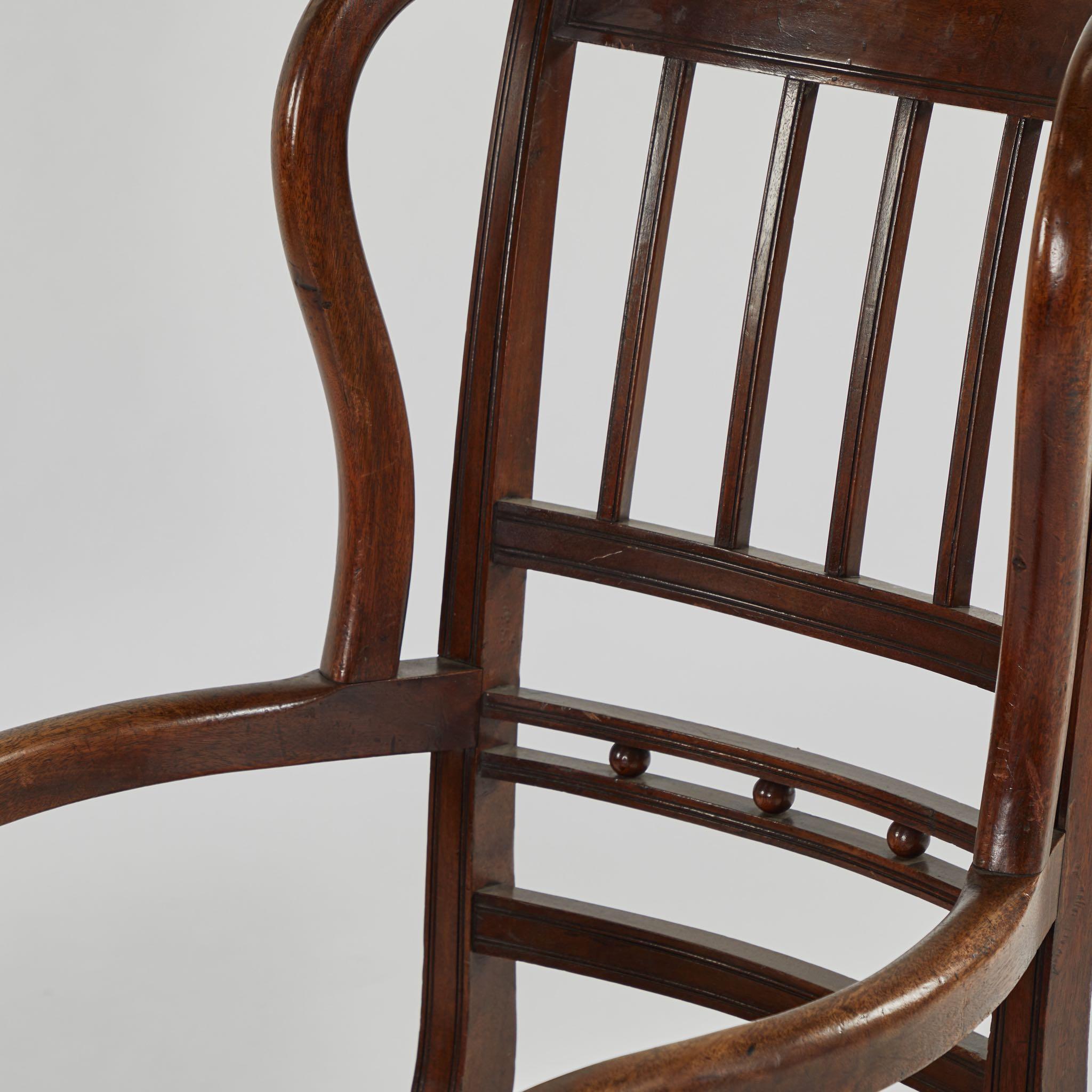 An armchair in walnut with winged back, originating in England, circa 1820.