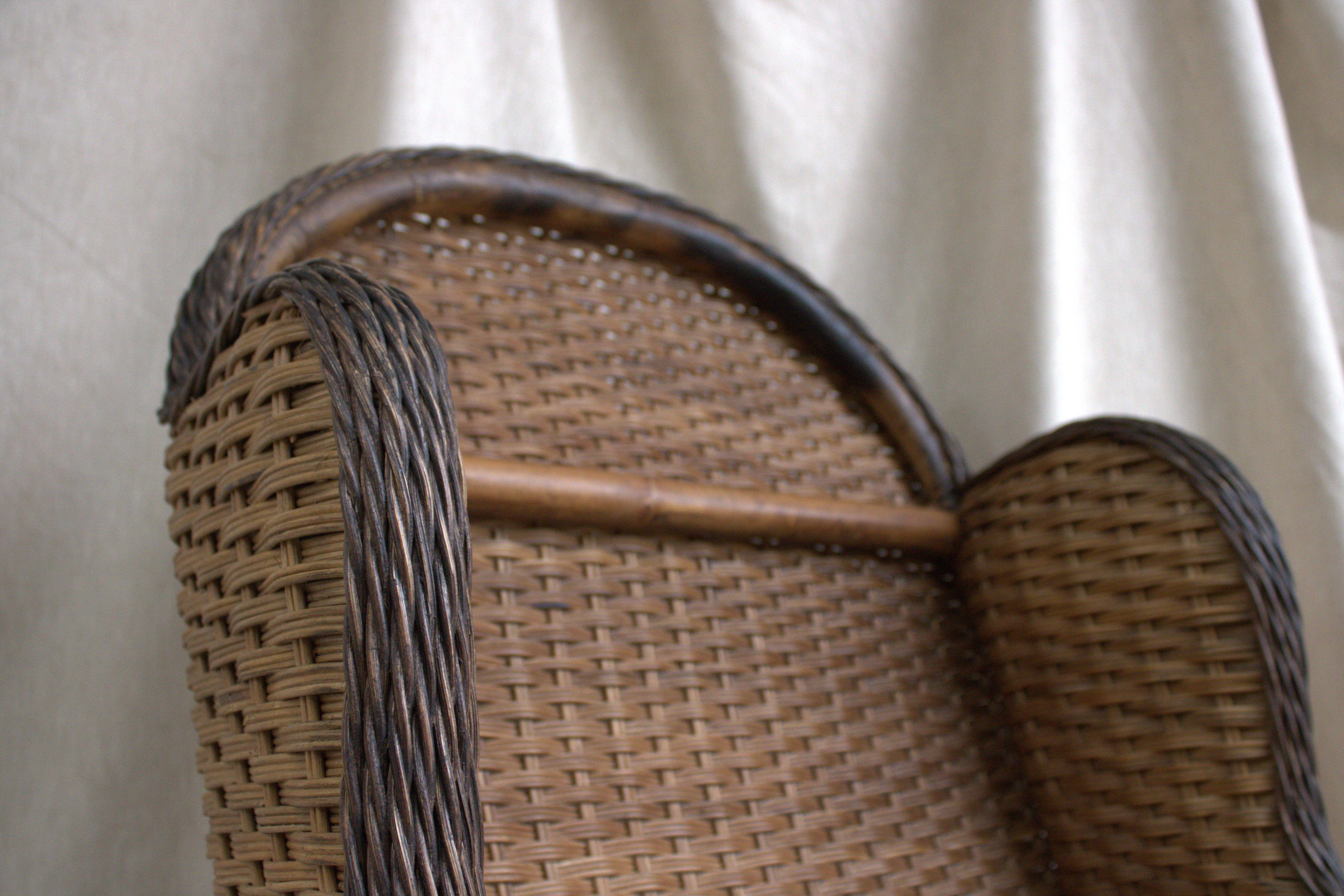 Chaise à accoudoirs en rotin tressé de paille avec des détails en forme de coquille sculptés sur de fins accents de bois.

Les détails en bois sculpté en forme de coquille nous incitent à penser que ce bel exemple, reproduit vers 1980, date de la