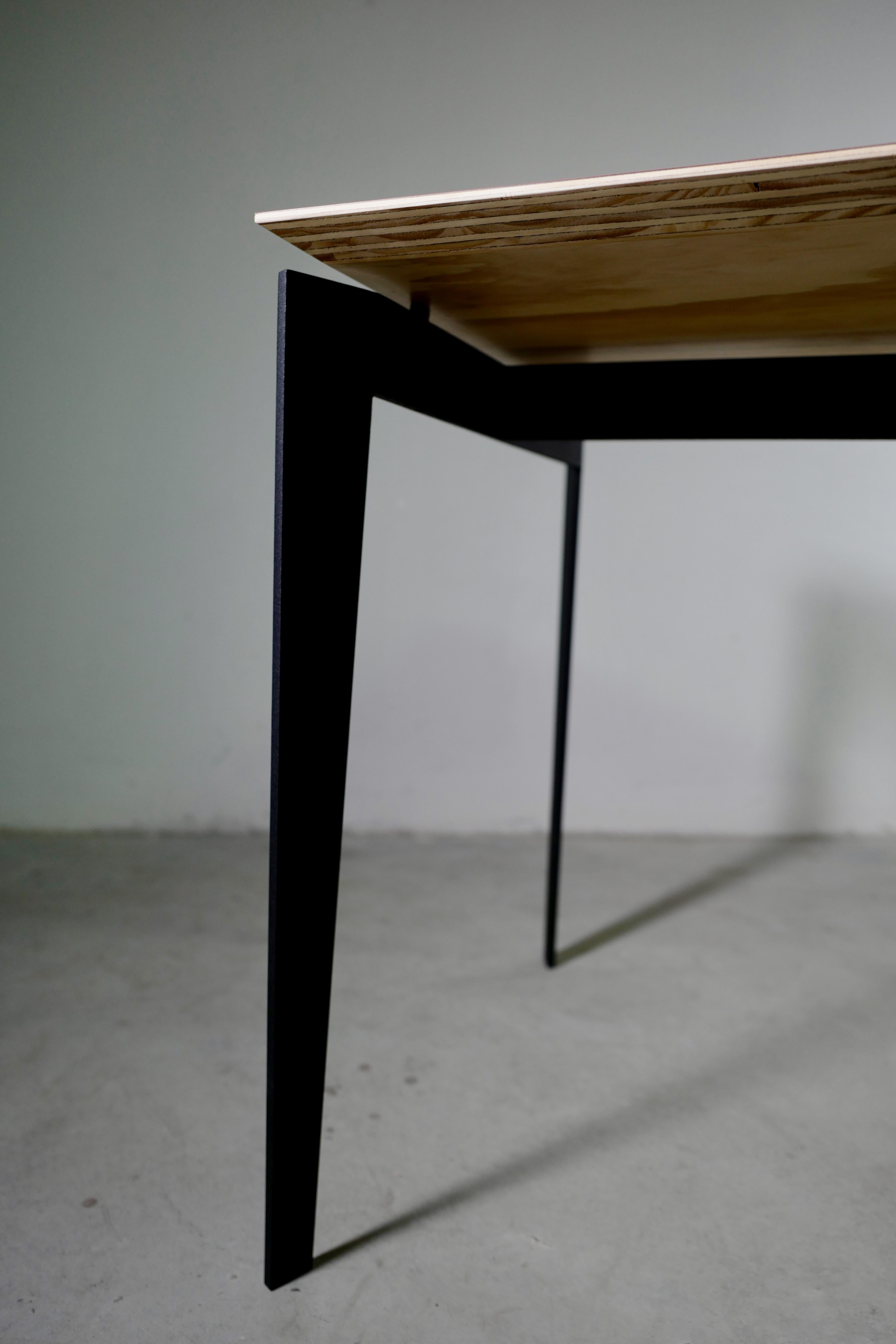 Une table multifonctionnelle compacte, un bureau italien contemporain rectangulaire avec un contreplaqué de bouleau de 24 mm et un plateau en stratifié plastique mat de 1 mm. Les pieds et le cadre sont fabriqués en fer thermolaqué avec une finition