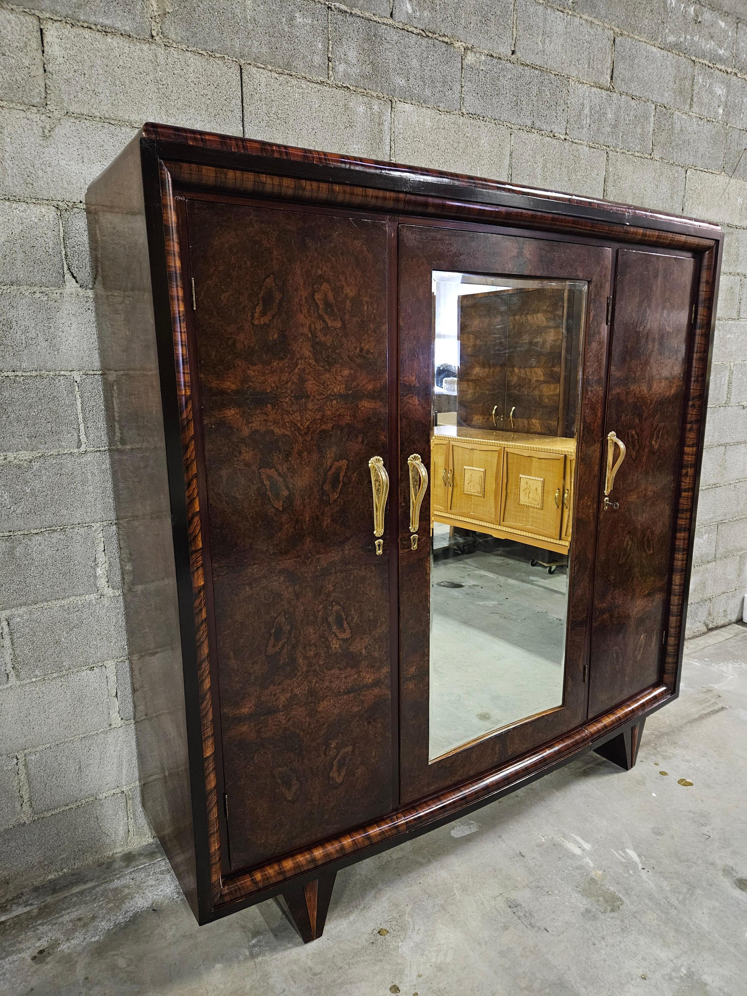 Art Deco style three-door closet, 1930s Italian production of high quality and workmanship.

The cabinet has three doors with ample interior space; on the left is a small shelf with hanging rod underneath.
In the center is a beautiful mirrored door