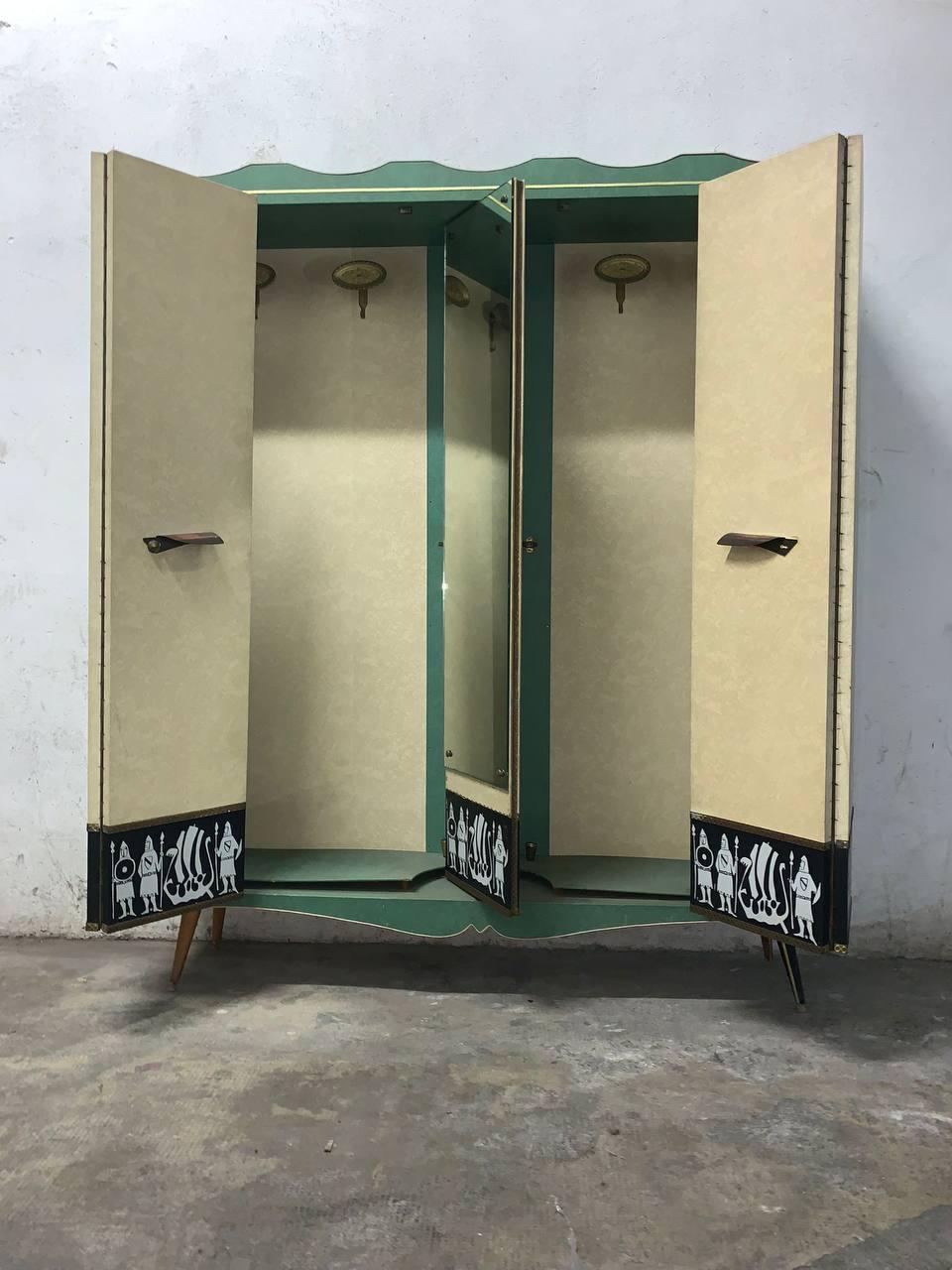 Une armoire basse unique, conçue en Italie par Umberto Mascagni. Cette pièce comporte des portes en cuir  vinyle gris avec poignées décorées en  beige, vert et noir. Centré par un grand miroir rotatif.
L'intérieur est garni d'élégantes suspensions