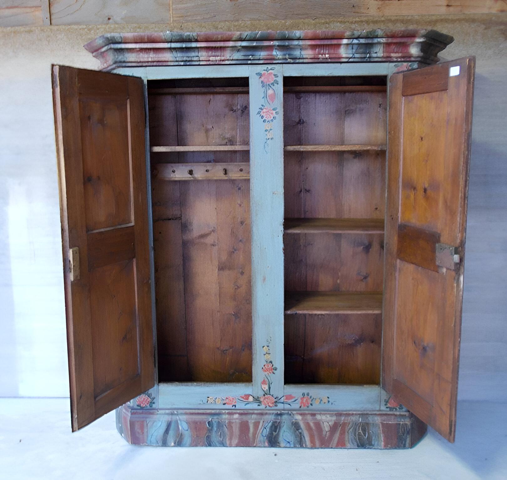 Spruce cabinet with shelves and coat rack.
Original hardware of the period complete with opening latch on left sash.

Between the 2 doors is a pilaster with floral motifs.

Frame and base are decorated with faux marble in various colors.

Of limited