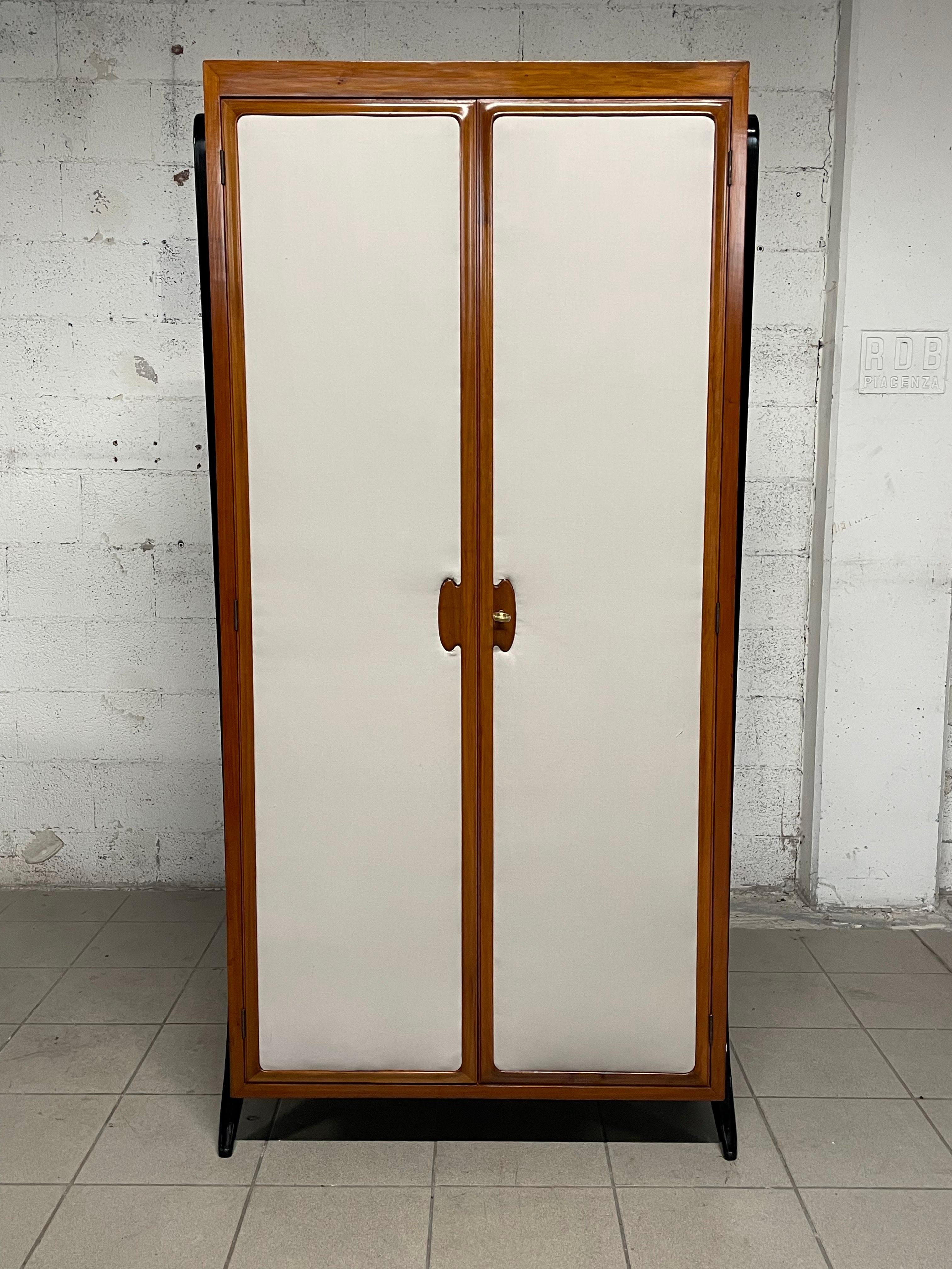 Closet - wardrobe 1950s. 

Small size but with space inside organized in hangers and shelves.
Pear wood frame with ebonized wood supports.
The front of the two doors is covered with fabric panels.
The cabinet has been completely restored in a