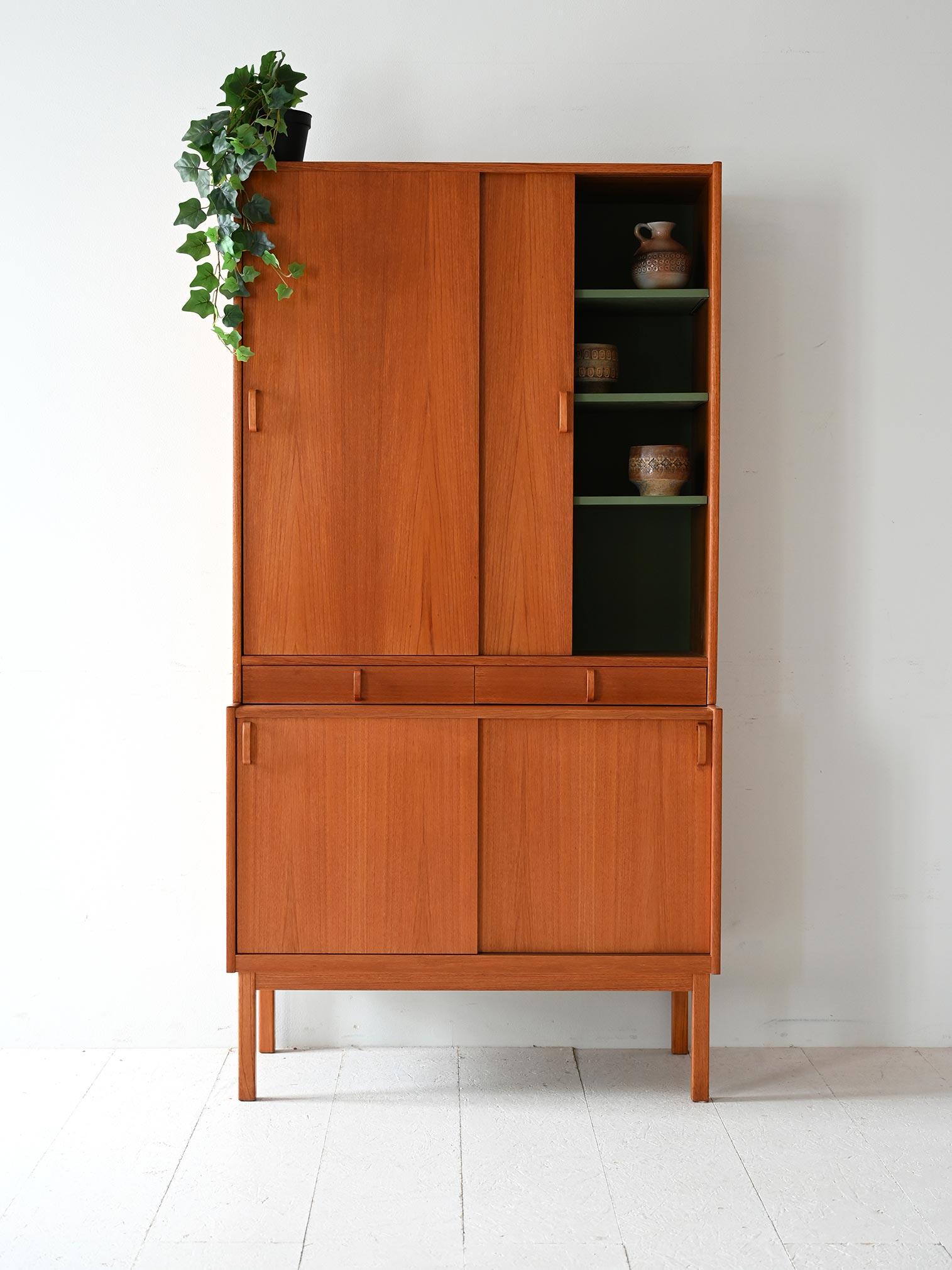 Teak closet with storage compartments, interior shelves and sliding doors at both top and bottom. Produced by Bodafors.

This cabinet is a design by Bertil Fridhagen for Bodafors, probably made in the 1950s or 1960s. The frame is divided into two
