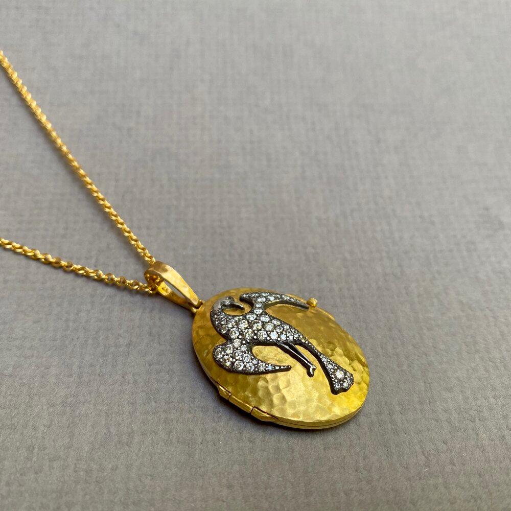 Oval hammered gold phoenix locket in 22k gold and oxidized silver.

Diamonds 0.64ct . 18” gold chain

Designed and handmade in Los Angeles