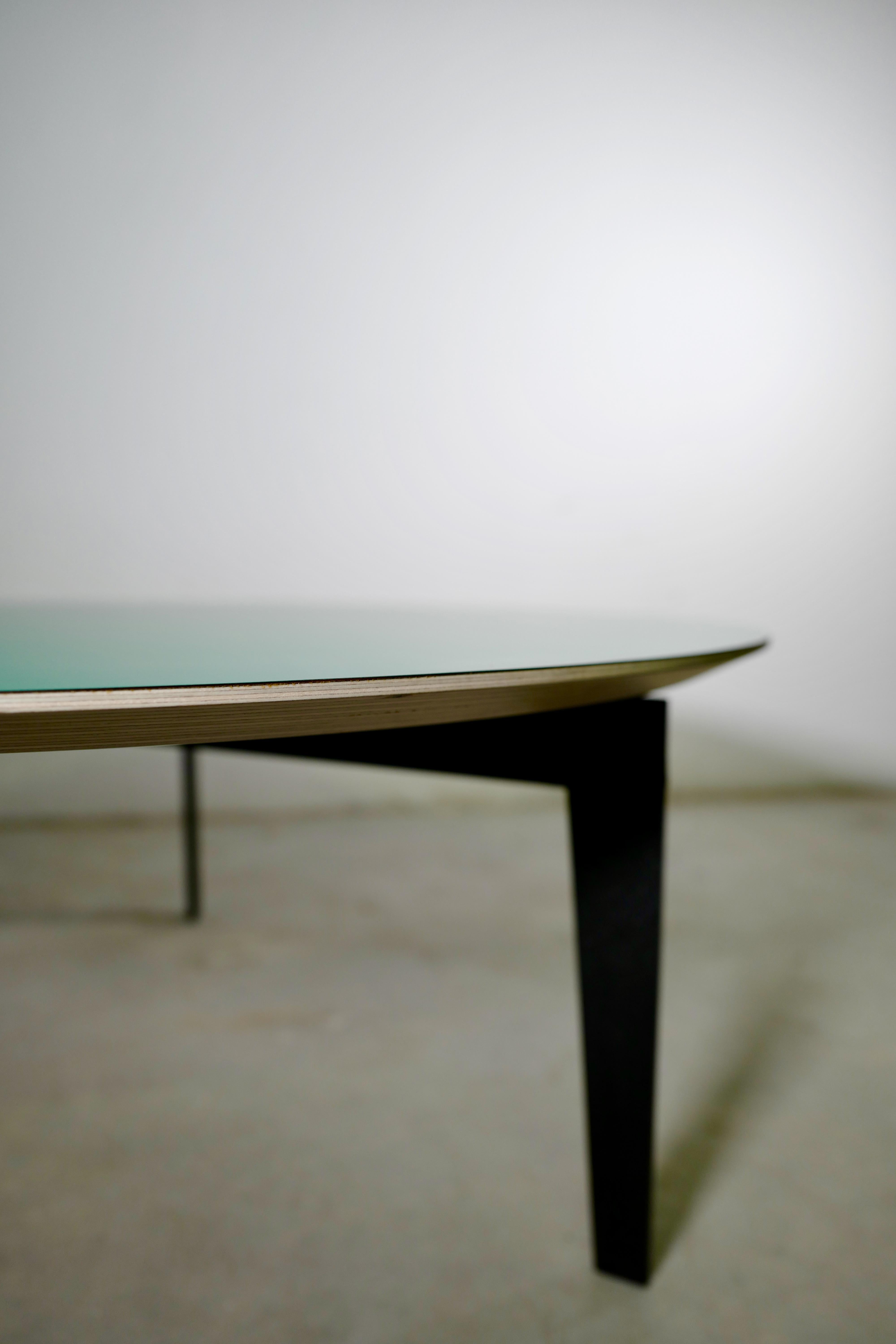 Une grande et joyeuse table ronde italienne contemporaine pour le café et le centre, avec un contreplaqué de bouleau de 24 mm et un plateau en stratifié plastique mat de 1 mm. Les pieds et le cadre sont en fer thermolaqué avec une finition noire