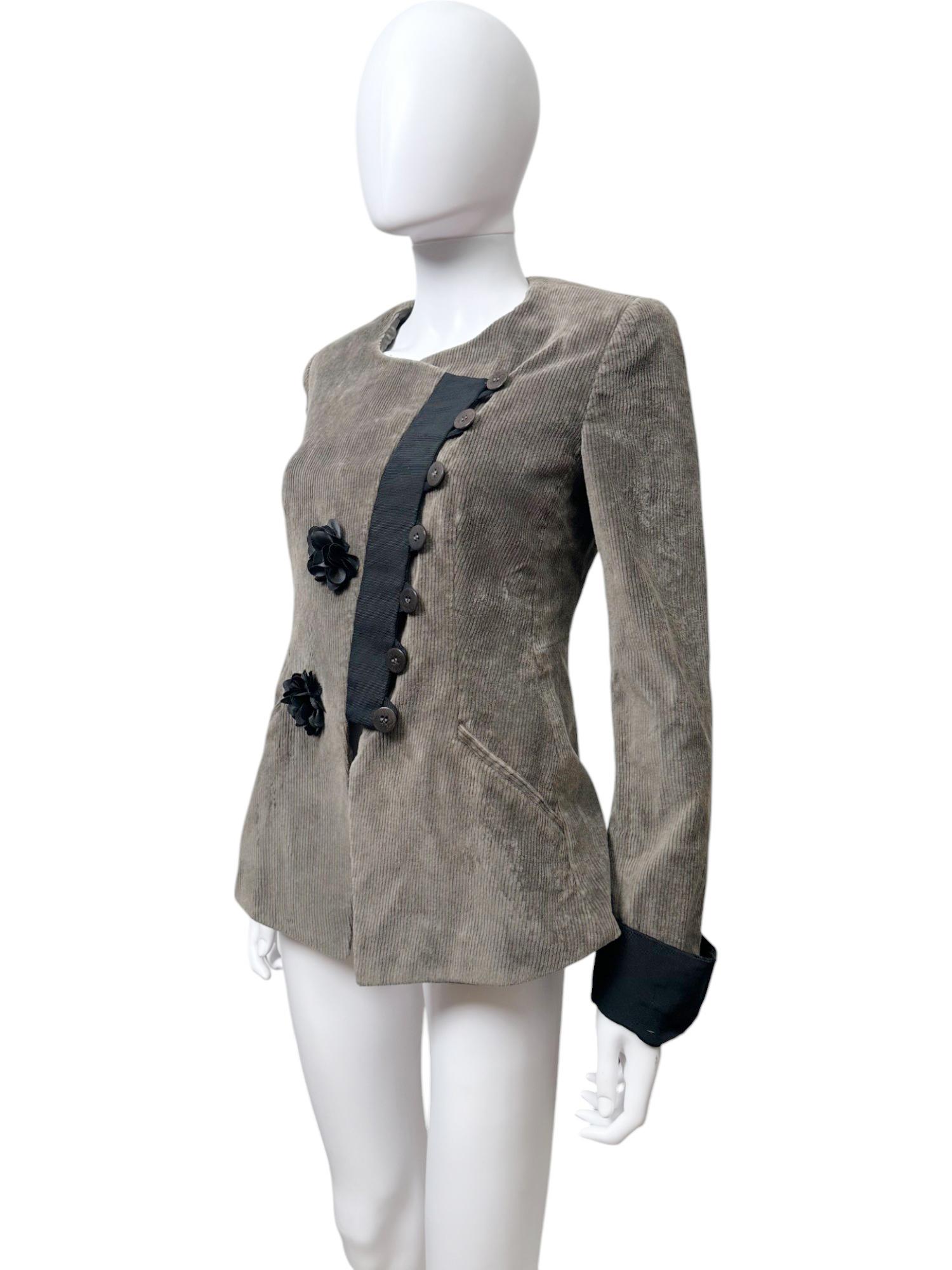 - Diseñado por Giorgio Armani.
- Colección Otoño-Invierno 2003.
- Chaqueta marrón abotonada.
- Cierre de botones asimétrico.
- Detalles de las flores.
- Línea de cuello redondo.
- Exterior en terciopelo y algodón.
- Forro de seda.
- Fabricado en