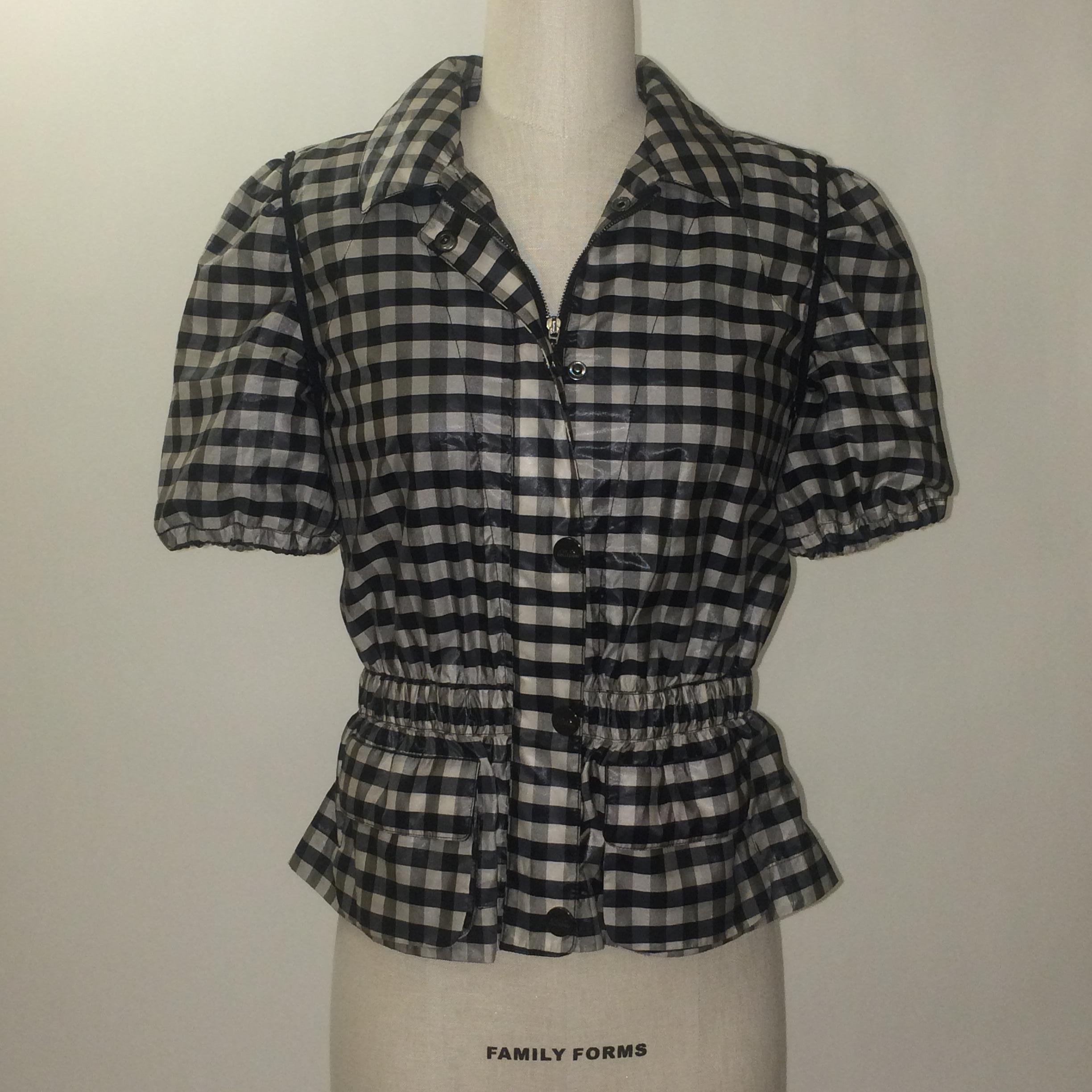 Armani Collezioni by Giorgio Armani short sleeved jacket in a very pale grey and black checked pattern. Elastic at hem of short sleeves. Zips and snaps up front with adjustable hidden elastic at waist. Patch pockets at front bottom. Signed 'Armani
