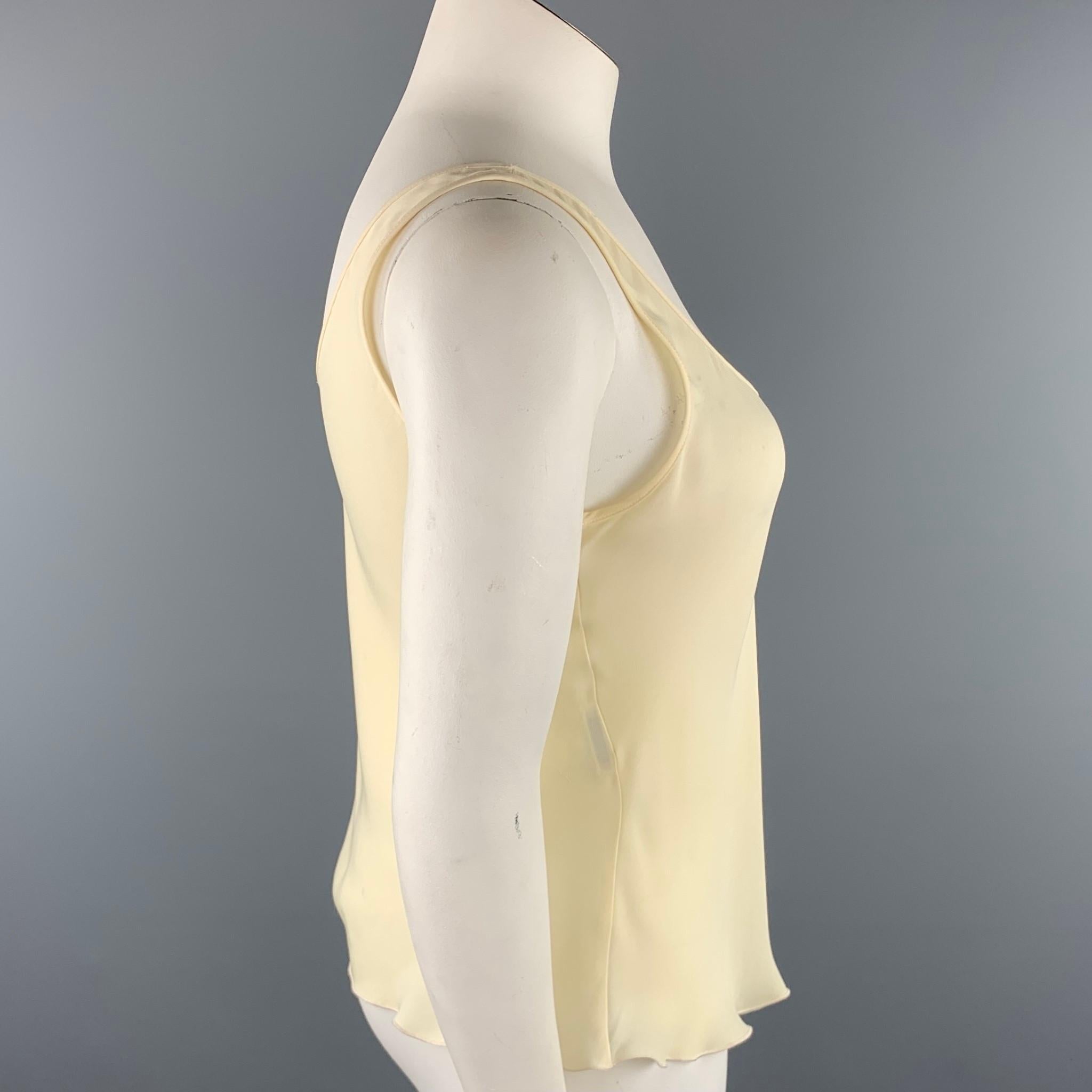 ARMANI COLLEZIONI camisole blouse comes in a cream silk blend featuring a scoop neck.

Very Good Pre-Owned Condition.
Marked: 12
Original Retail Price: $295.00

Measurements:

Bust: 36 in. 
Length: 17 in. 