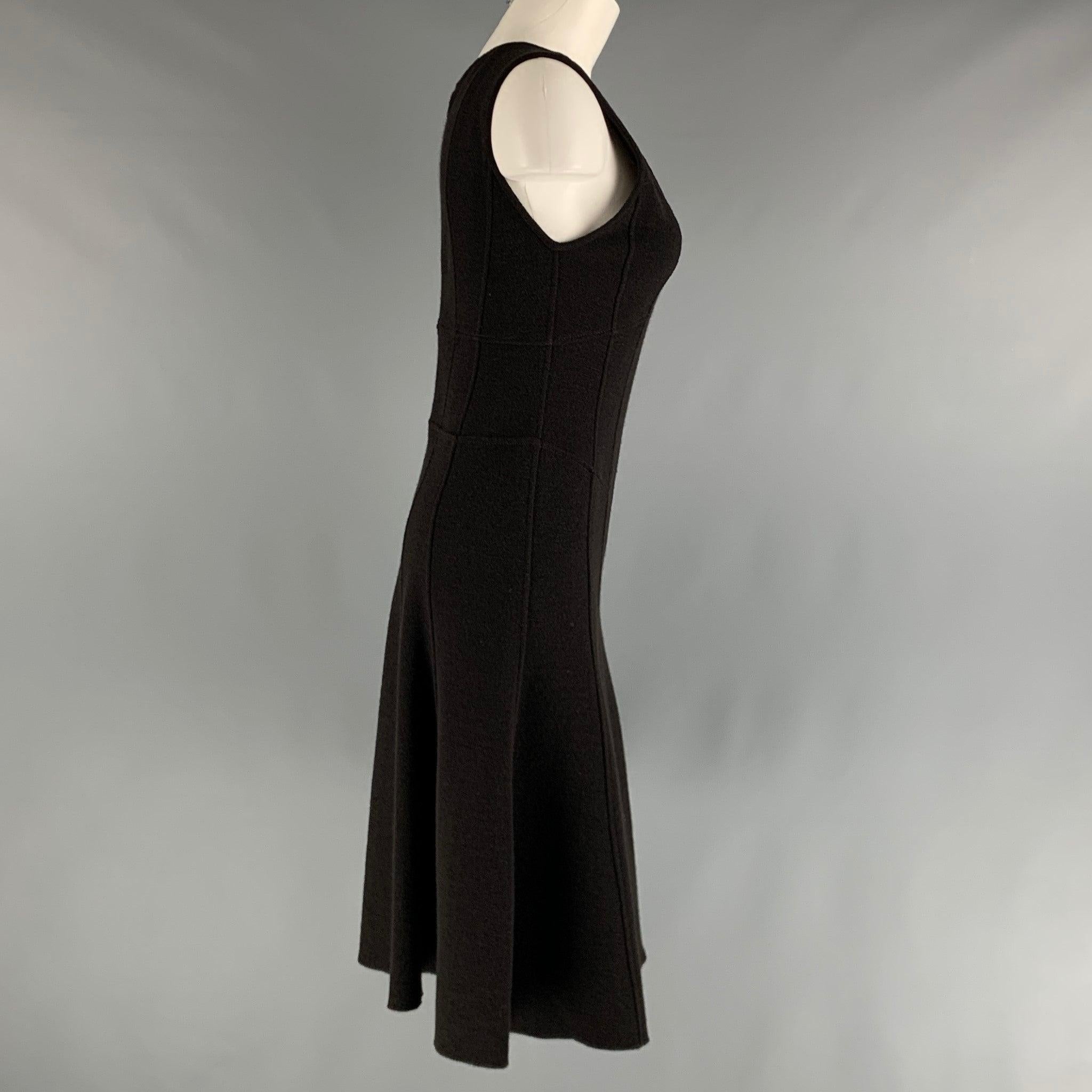 La robe ARMANI COLLEZIONI est réalisée en maille de laine noire et présente un style a-line, une encolure dégagée et une fermeture à glissière dans le dos. Fabriqué en Italie. Très bon état. 

Marqué :  4 

Mesures : 
 
Épaule : 14 pouces Buste : 32
