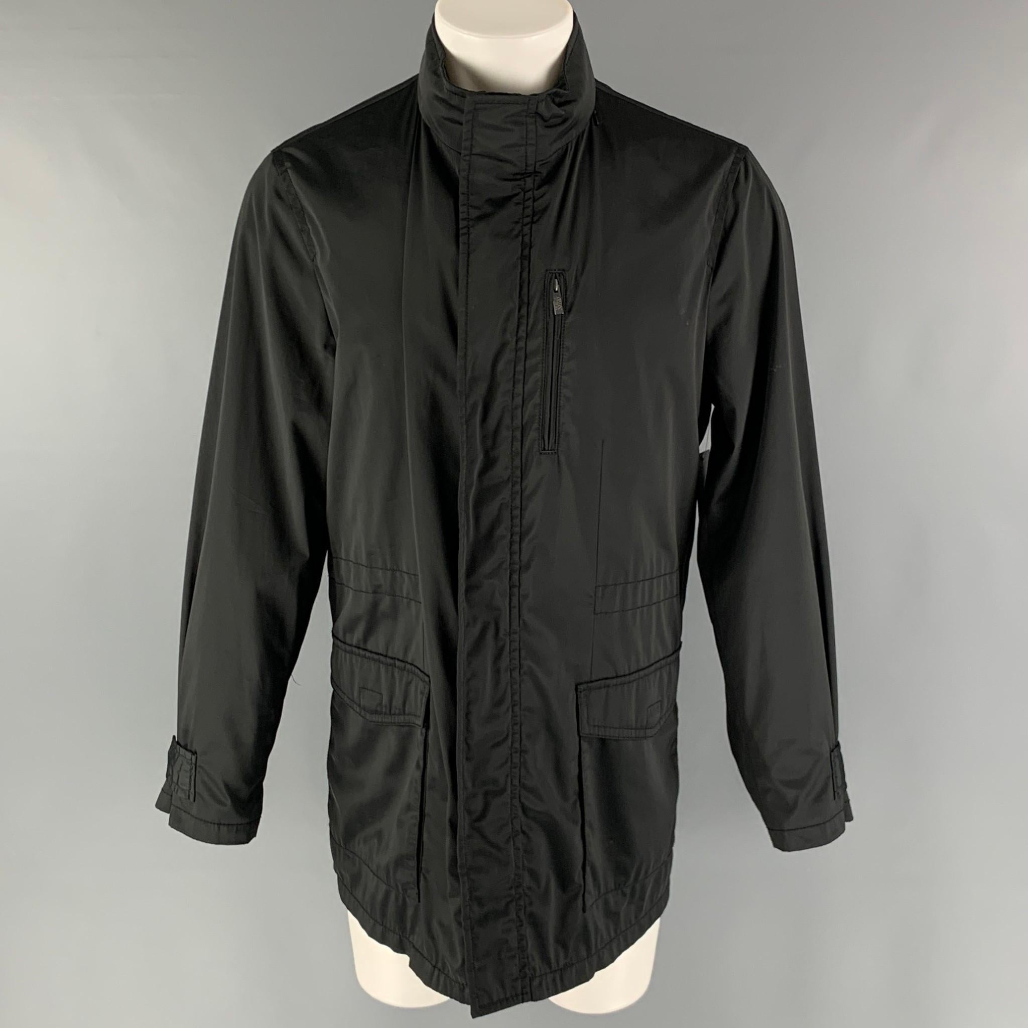 ARMANI COLLEZIONI windbreaker jacket comes in a black polyester water repellent woven material featuring a park style, patch pockets, internal hood, and a zip up and snap button closure.

Excellent Pre-Owned Condition.
Marked: