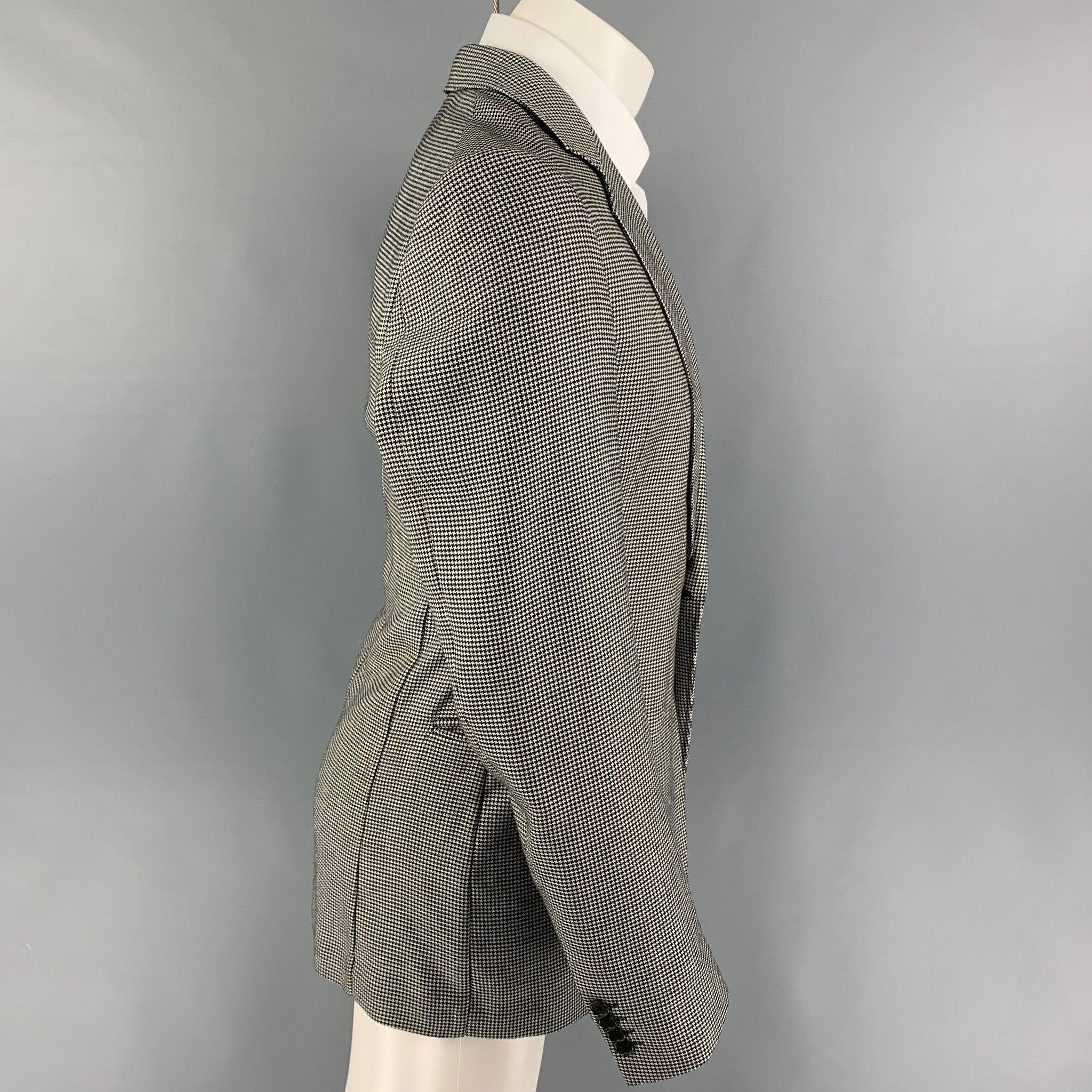 ARMANI COLLEZIONI sport coat comes in a black & white houndstooth polyester / rayon with a half liner featuring a notch lapel, slit pockets, and a single button closure.
Very Good
Pre-Owned Condition.  

Marked:   40 L  

Measurements: 
 
Shoulder: