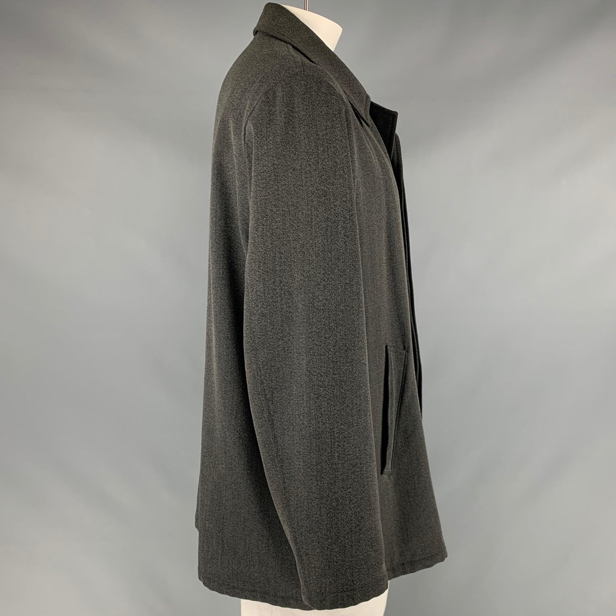 ARMANI COLLEZIONI coat
in a grey and black wool cotton blend sport fabric featuring nailhead pattern, single breasted style, two pockets, and a hidden button closure.Good Pre-Owned Condition. Moderate signs of wear. As is. 

Marked:   42