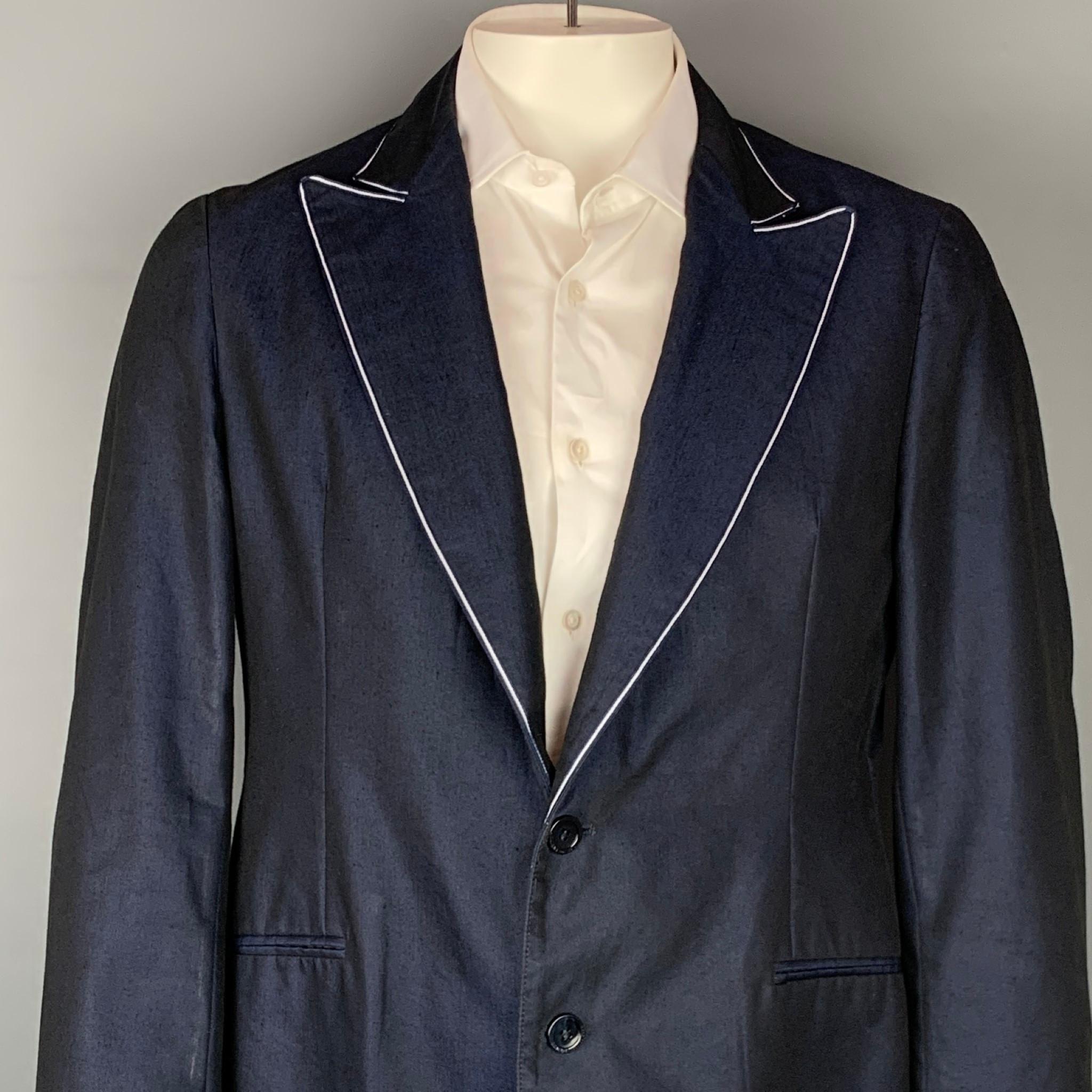 ARMANI COLLEZIONI sport coat comes in a navy & & white linen / polyester with a half piping liner featuring a peak lapel, slit pockets, and a two button closure. Made in Romania.

Very Good Pre-Owned Condition.
Marked: 42

Measurements:

Shoulder: