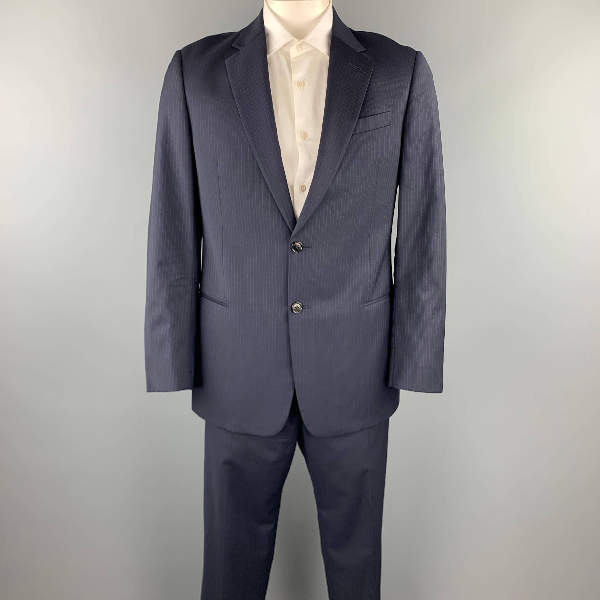 ARMANI COLLEZIONI suit comes in a navy pinstripe wool and includes a single breasted, two button sport coat with a notch lapel and matching flat front trousers. Made in Italy.

Excellent Pre-Owned Condition.
Marked: 42