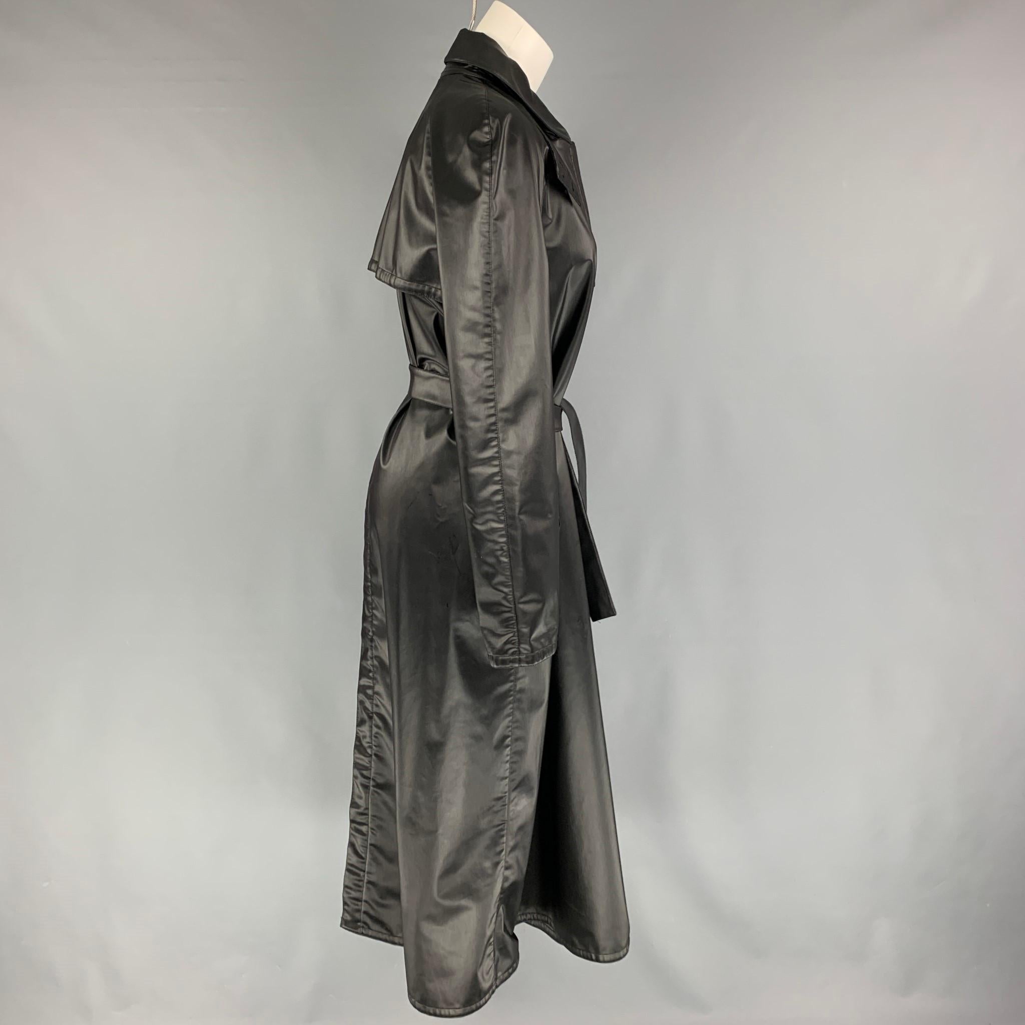 ARMANI COLLEZIONI raincoat comes in a black polyester blend featuring a belted style, slit pockets, back buttoned slit, and a hidden placket closure. Made in Italy. 

Very Good Pre-Owned Condition.
Marked: 6

Measurements:

Shoulder: 16 in.
Bust: 40