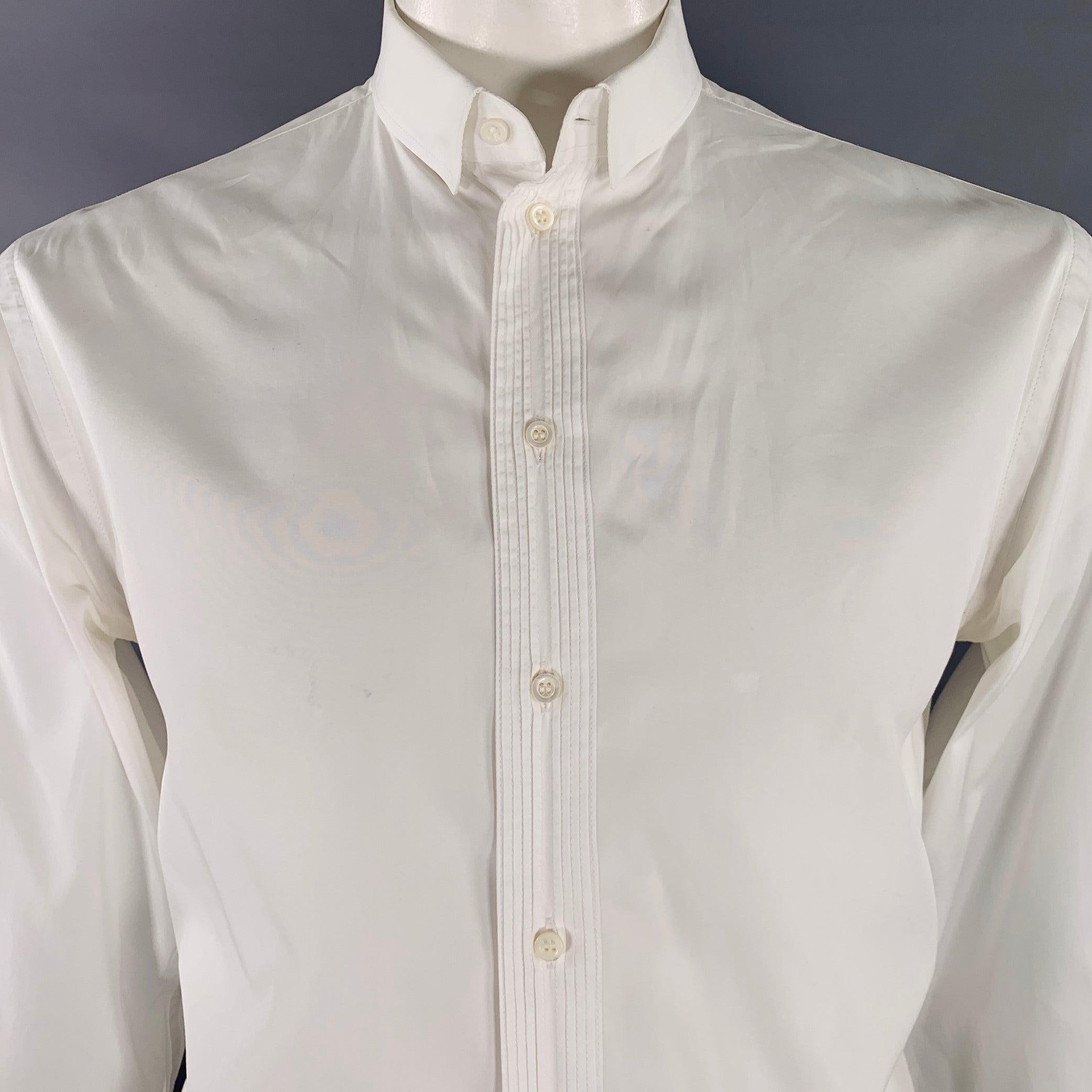 Camicia a maniche lunghe Armani Collezioni
in tessuto di cotone bianco con colletto a scatto nascosto, polsini alla francese e chiusura a bottoni con dettagli di abbottonatura a pieghe. I gemelli non sono inclusi. Made in Italy. Eccellente