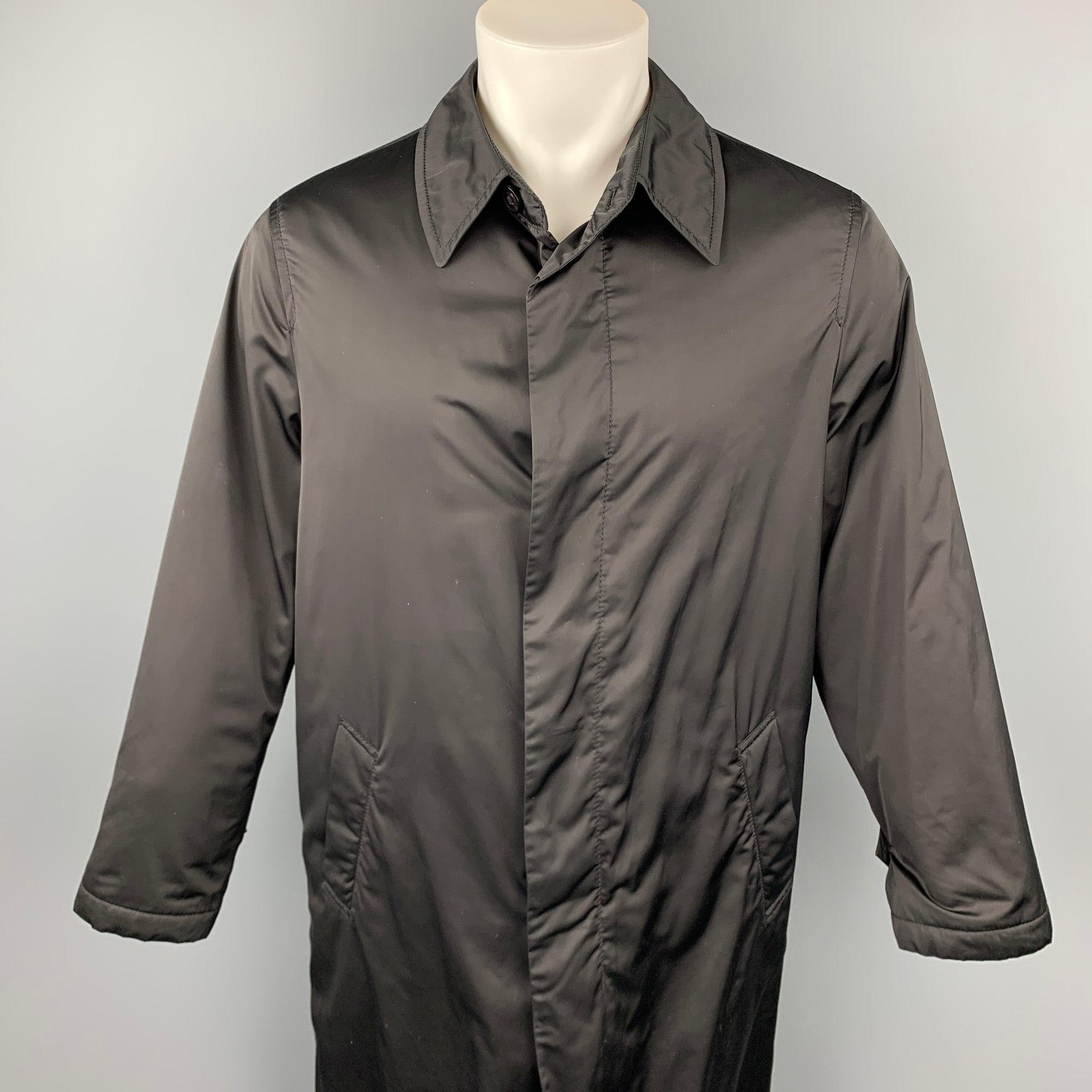 ARMANI COLLEZIONI raincoat comes in a black polyester with a rain repellent material featuring a spread collar, slit pockets, and a hidden button closure. Minor discoloration on the back.
 Good
 Pre-Owned Condition. 
 

 Marked:  40 
 

