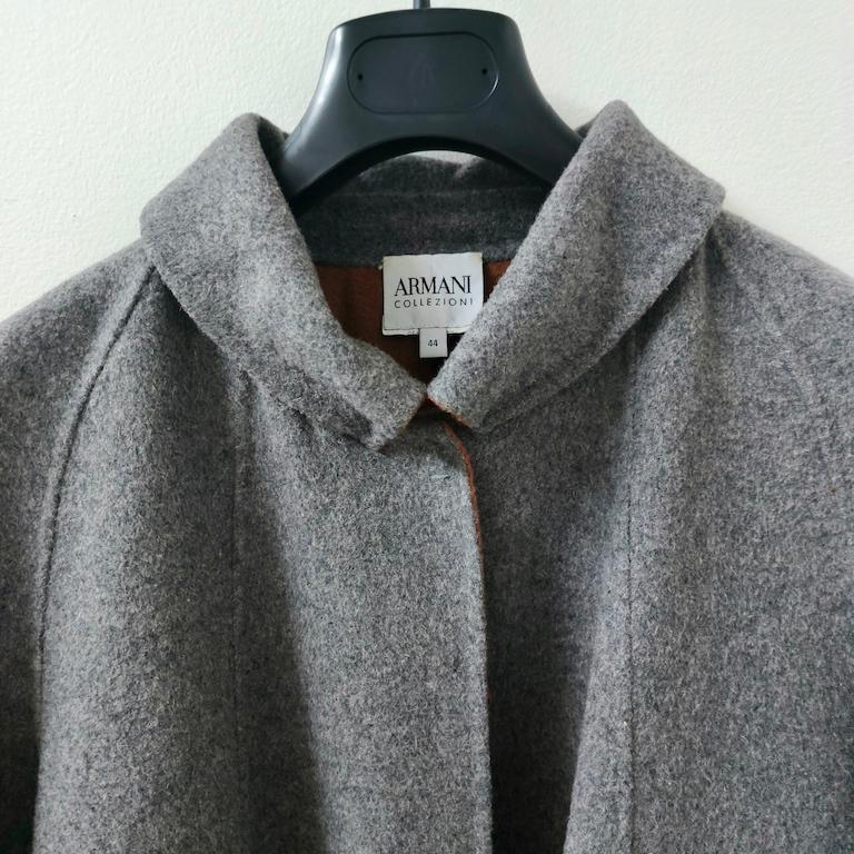 Avvolto nell’eleganza rilassata ma inconfondibile di Armani Collezioni, questo cappotto corto in pura lana double-face (esterno grigio antracite, interno in contrasto terracotta) è un piccolo gioiello di tailoring italiano pensato per accompagnare