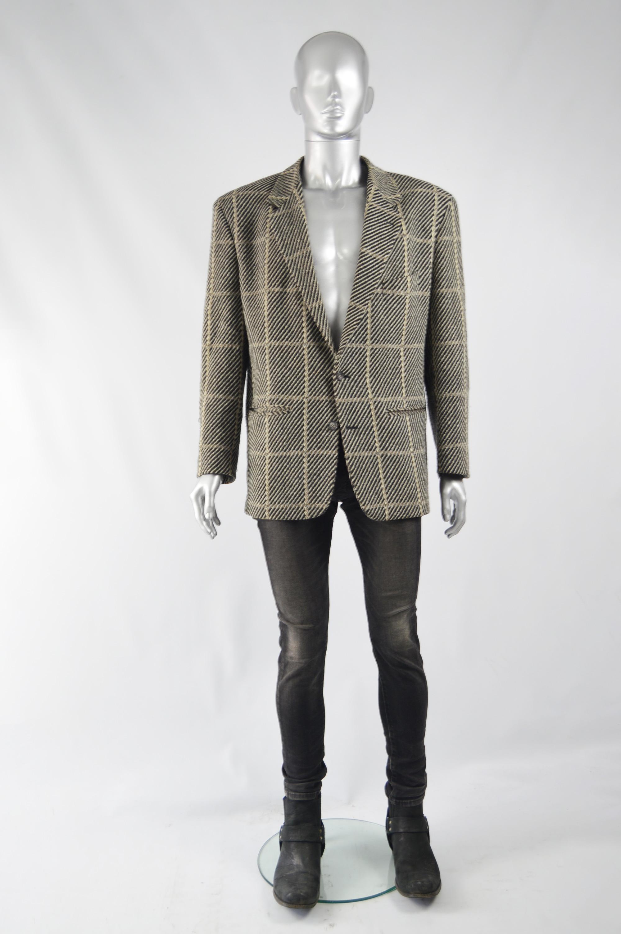 An excellent vintage blazer / sport coat from the 80s by Armani for his Emporio Armani line. In a checked wool fabric with bold shoulders and a single breasted button fastening and a plaid pattern lining. 

Size: Marked IT 54R which equates to an
