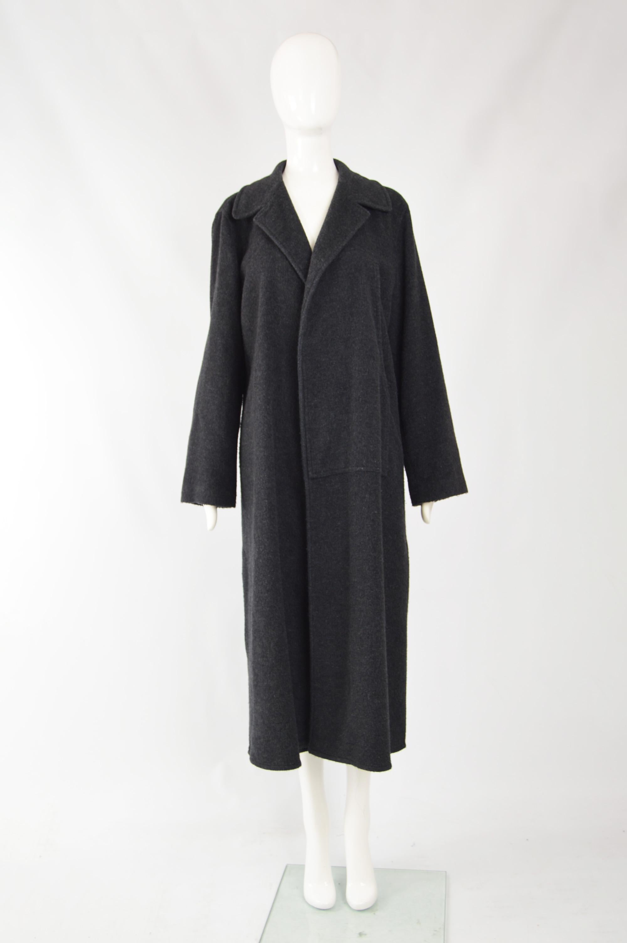 A chic vintage womens long overcoat from the 90s by Emporio Armani. In a charcoal grey wool blend (and blue interior) with no closures which makes the coat drape beautifully open when you walk, but it also looks great cinched in with a belt. (Please