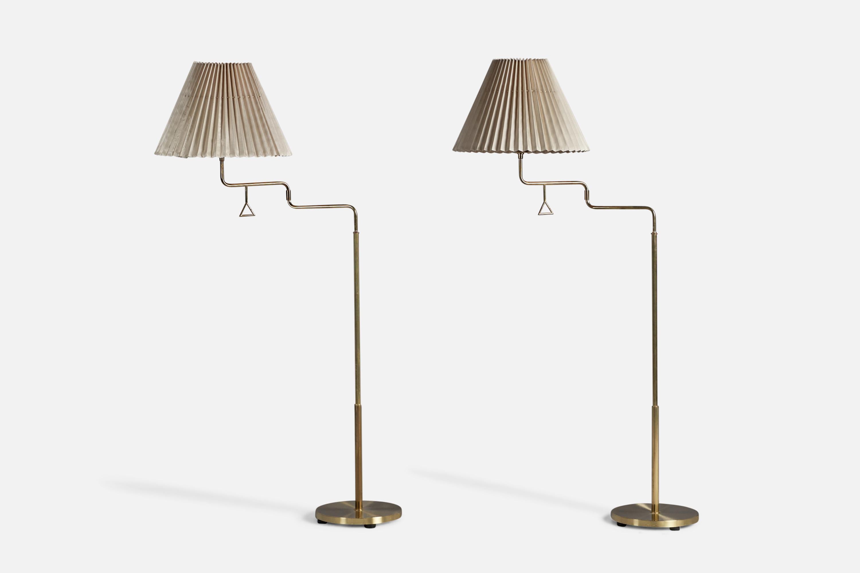 A pair of adjustable brass and light beige fabric floor lamp designed and produced by Armaturhantverk Tibro, Sweden, c. 1960s.

Fully Extended Dimensions (inches): 63
