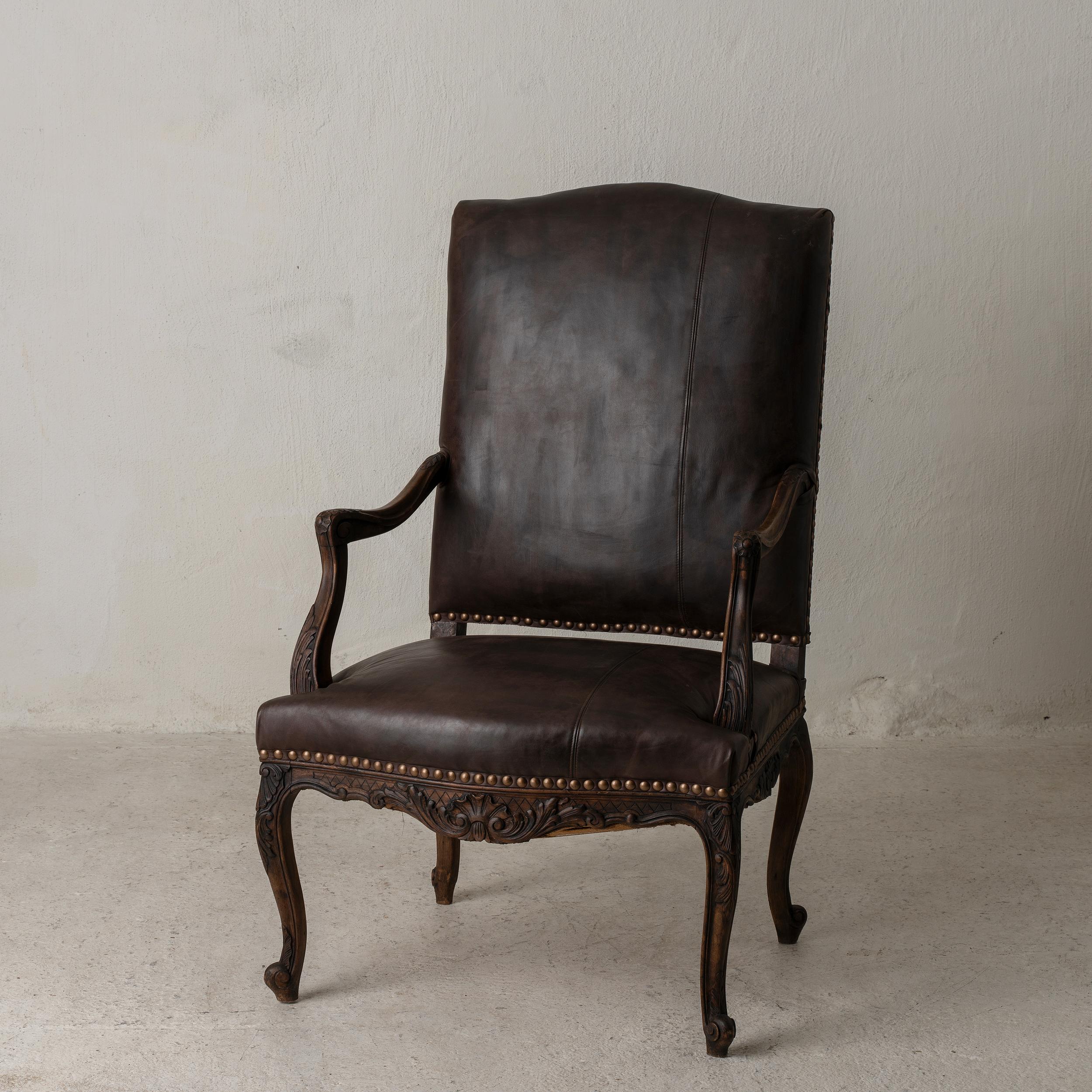 An armchair made in France during the 19th century. Made from polished oak and leather upholstery. 
